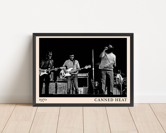 Canned Heat Poster in landscape mockup, framed black and white vintage band photo, leaning on white wall, wood floor.