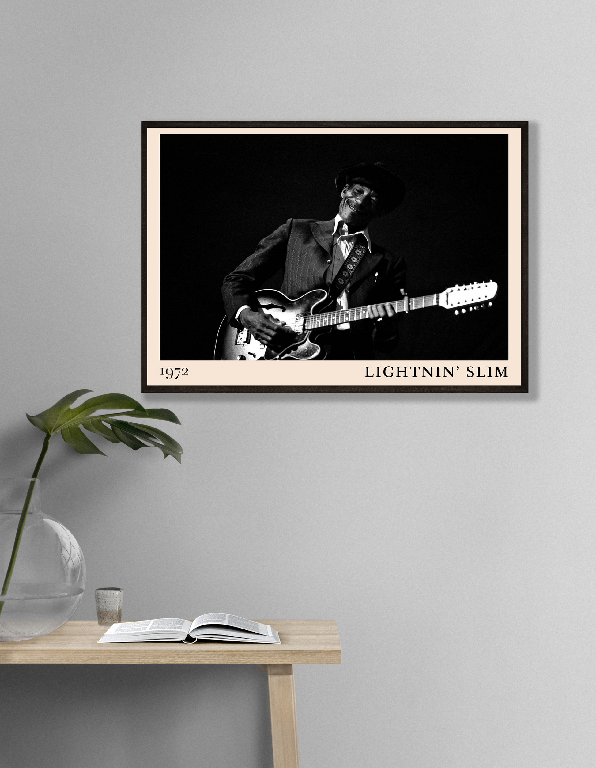 Lightnin Slim Blues Poster in landscape mockup, black and white guitar portrait on wall above minimalist wooden table.