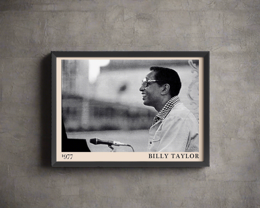 1977 photograph of Billy Taylor taken by Thomas Marcello. Picture crafted into a black framed poster, with an off-white border. Poster is hanging on a grey wall