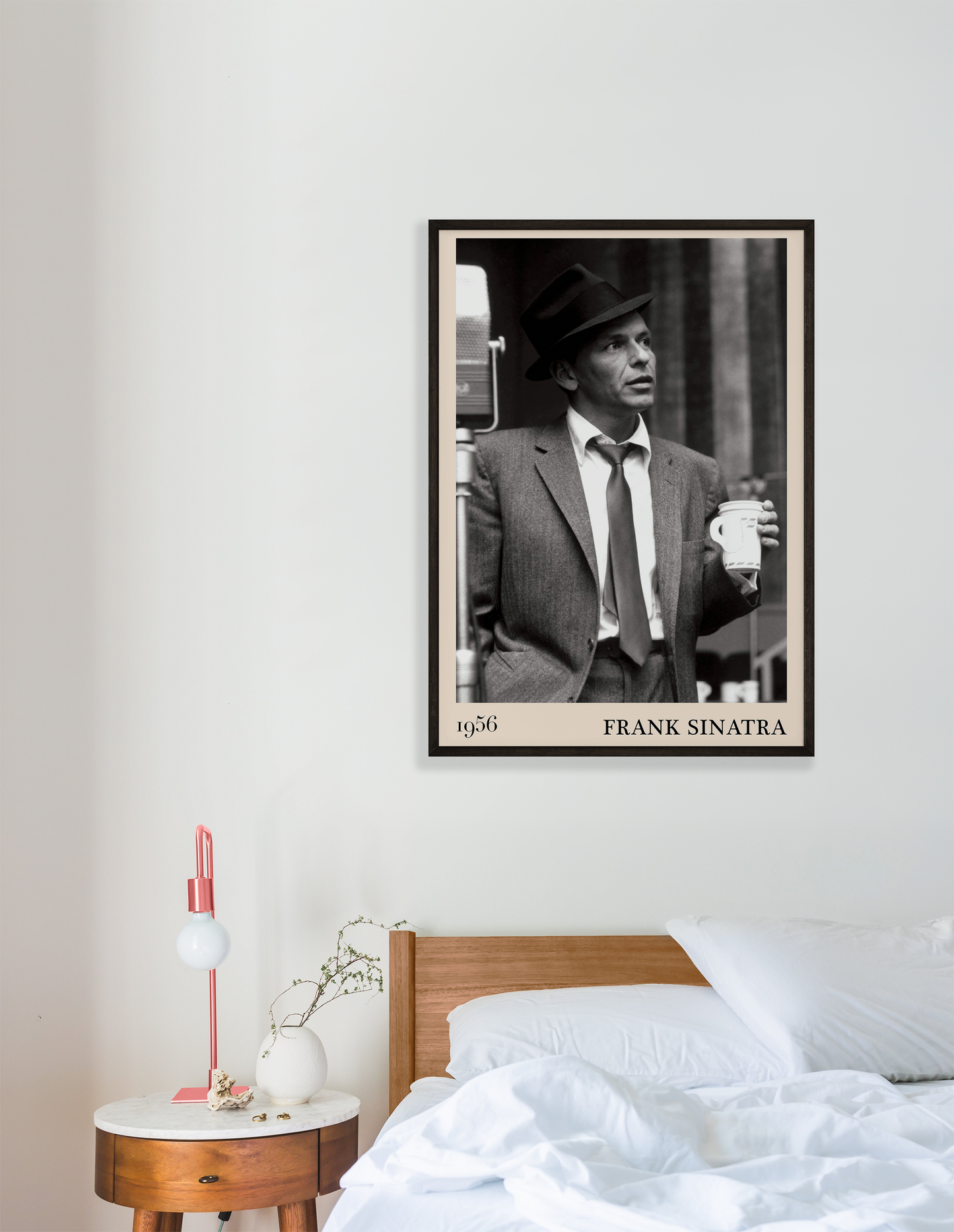 1956 photo of Frank Sinatra crafted into a black framed-poster, hanging on a white bedroom wall