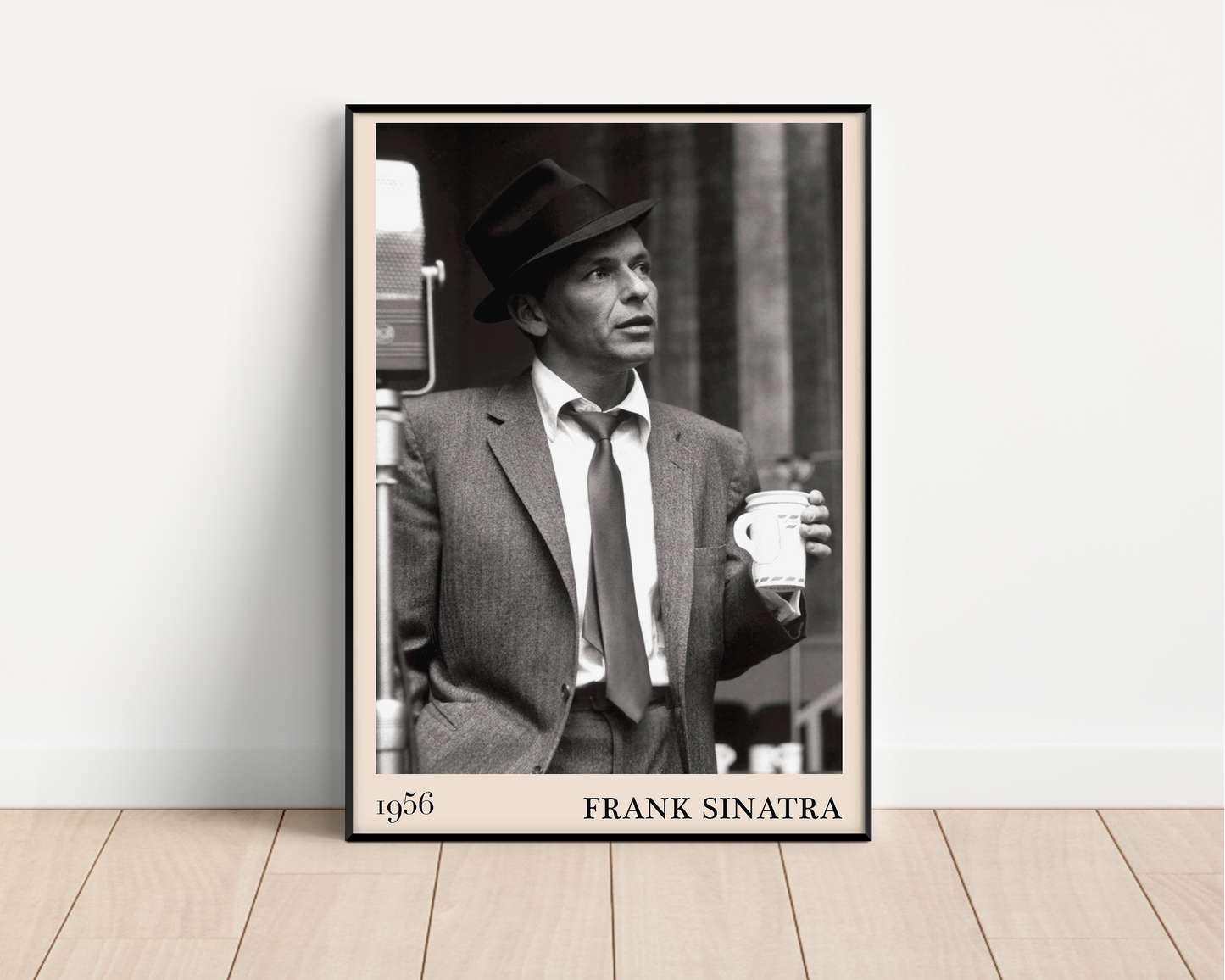 1956 photo of Frank Sinatra crafted into a black framed-poster, leaning against a white wall