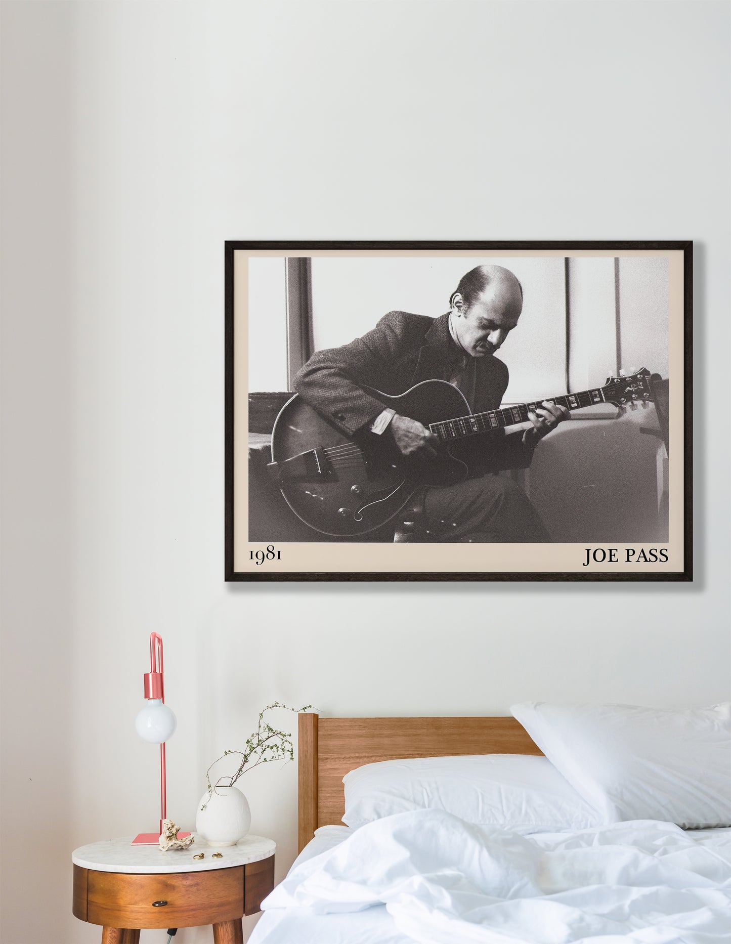 1981 photo of Joe Pass crafted into an elegant black-framed print. Hanging on a white bedroom wall