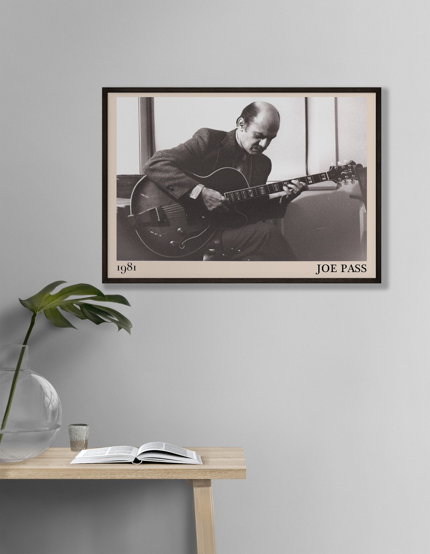 1981 photo of Joe Pass crafted into an elegant black-framed print. Hanging on a white living room wall