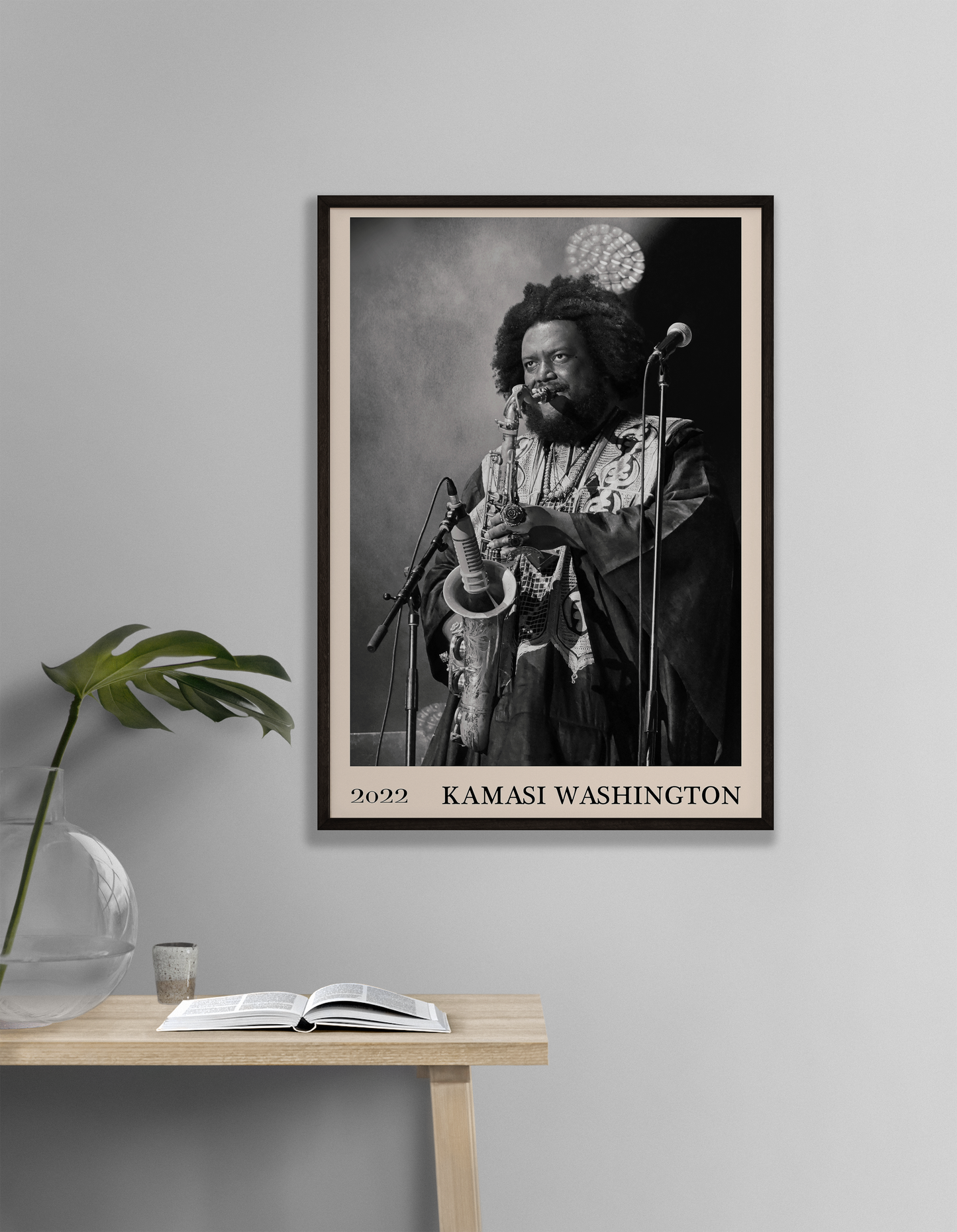 2022 photo of Kamasi Washington crafted into a black framed-poster, hanging on a white living room wall