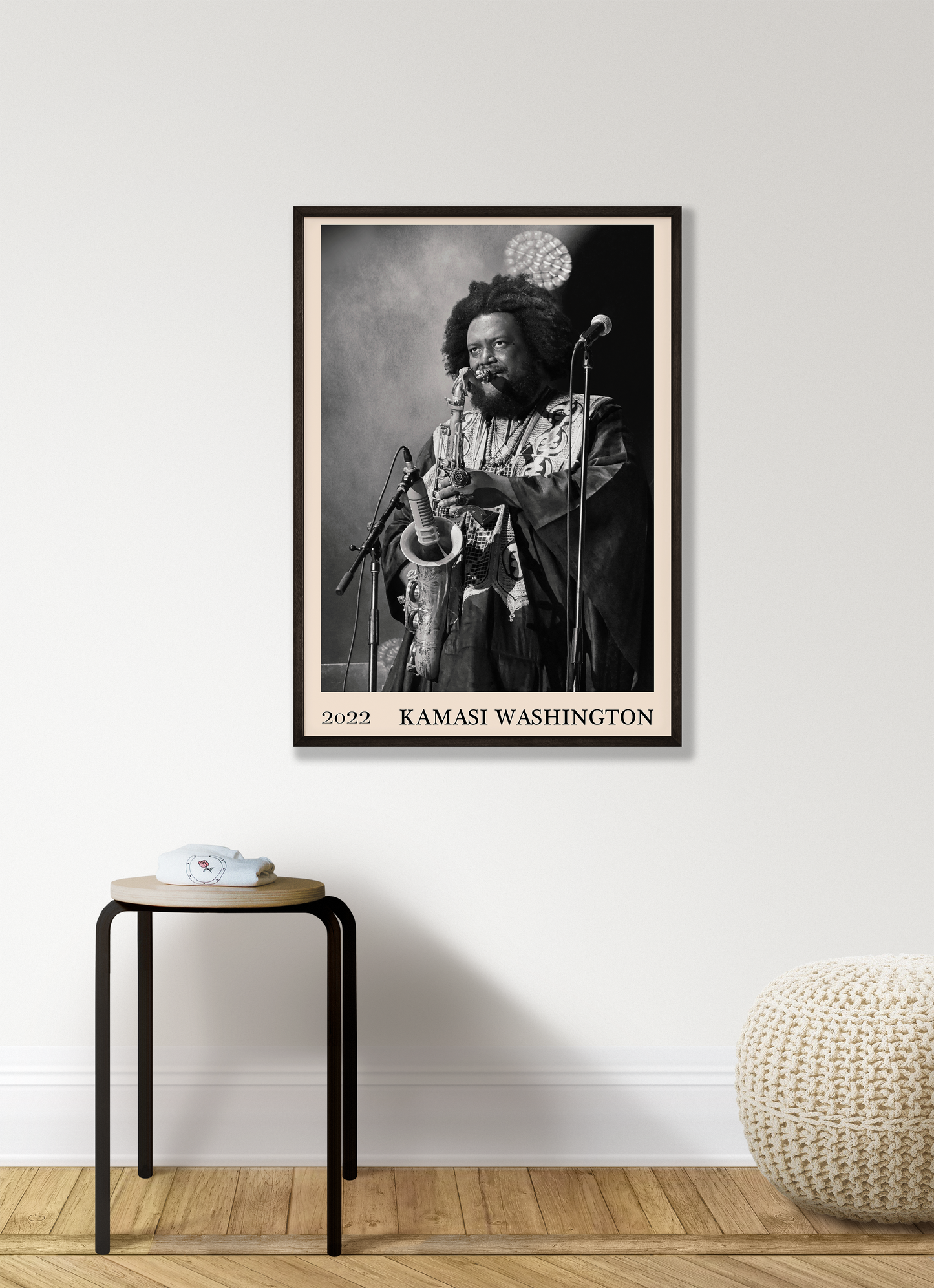 2022 photo of Kamasi Washington crafted into a black framed-poster, hanging on a white living room wall