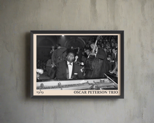 1959 picture of the Oscar Peterson Trio. Picture crafted into a black framed poster, with an off-white border. Poster is hanging on a brown wall
