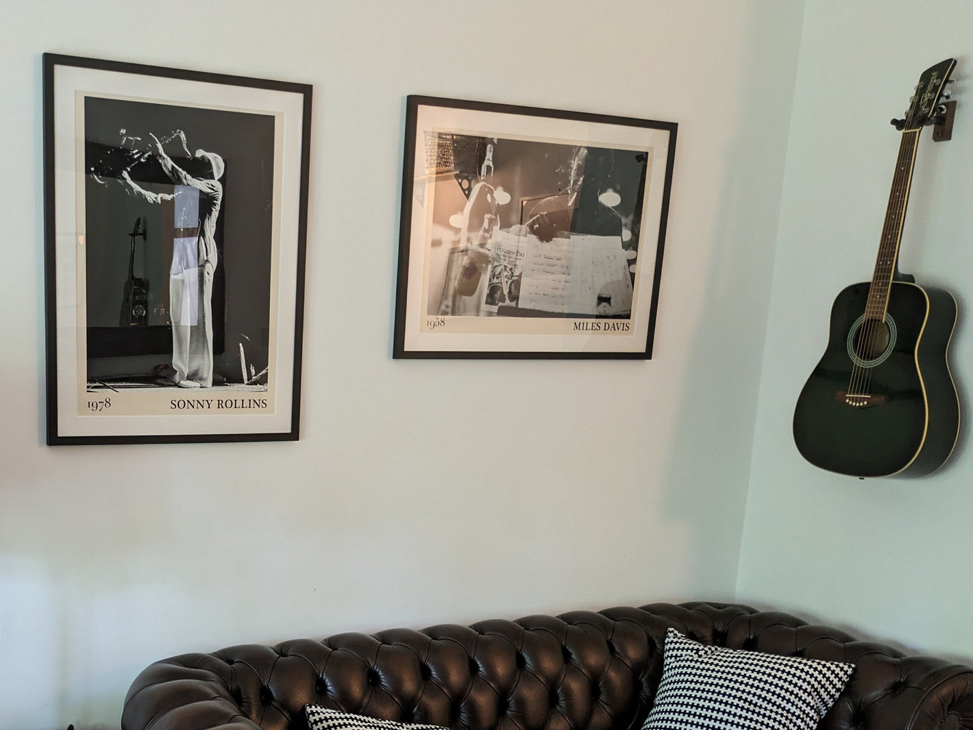 Framed posters of Miles Davis and Sonny Rollins hanging on a white wall