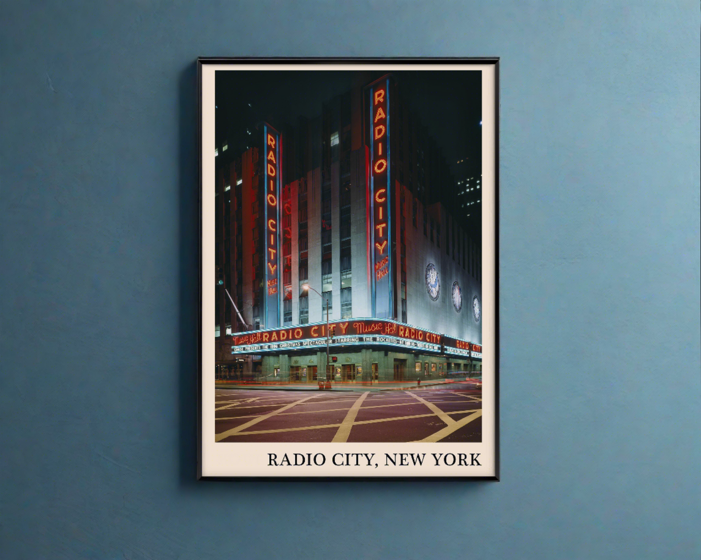 Iconic photo of Radio City in New York captured in a retro black framed jazz poster, hanging on a blue wall