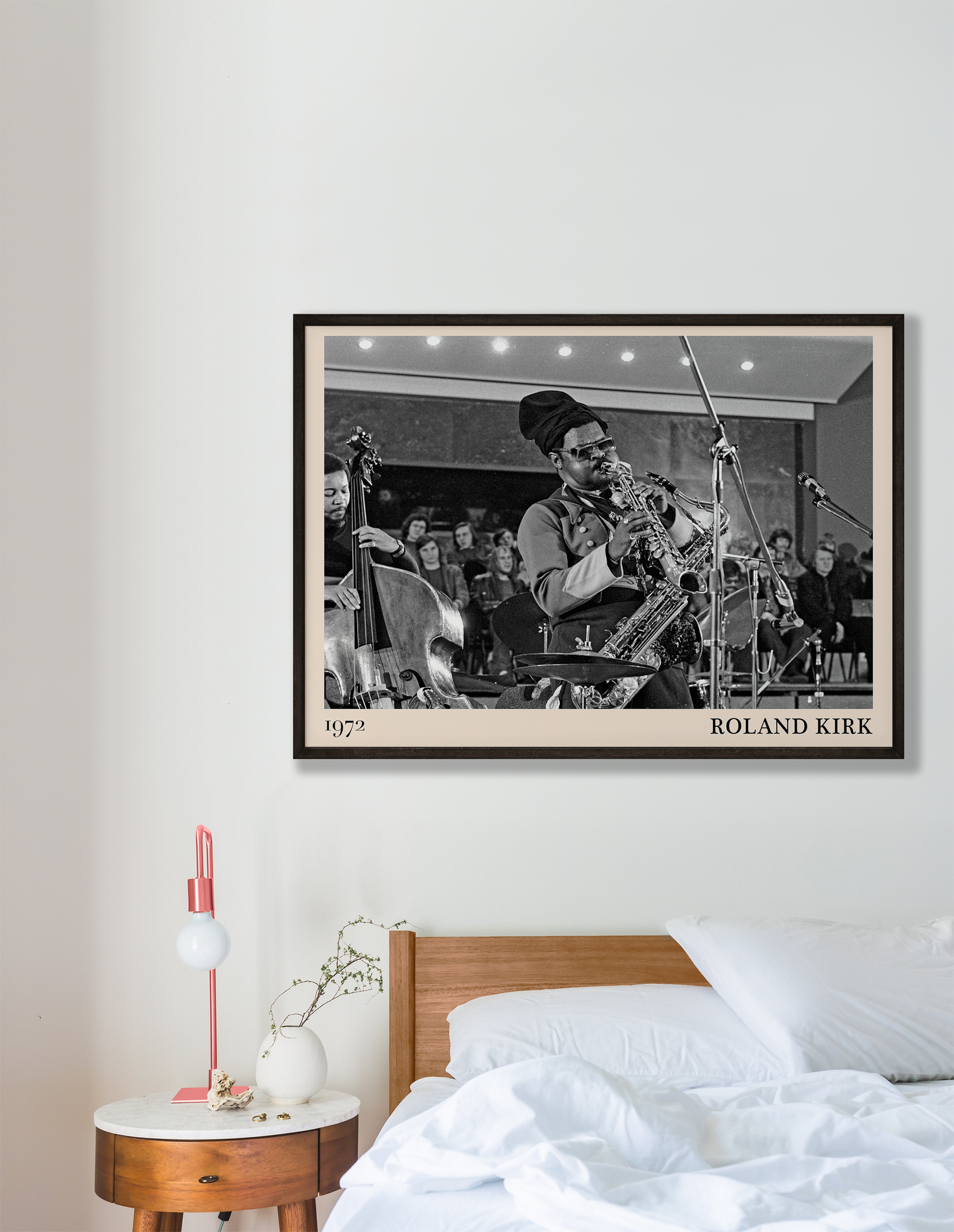 1972 photo of Roland Kirk crafted into a black framed-poster, hanging on a white bedroom wall