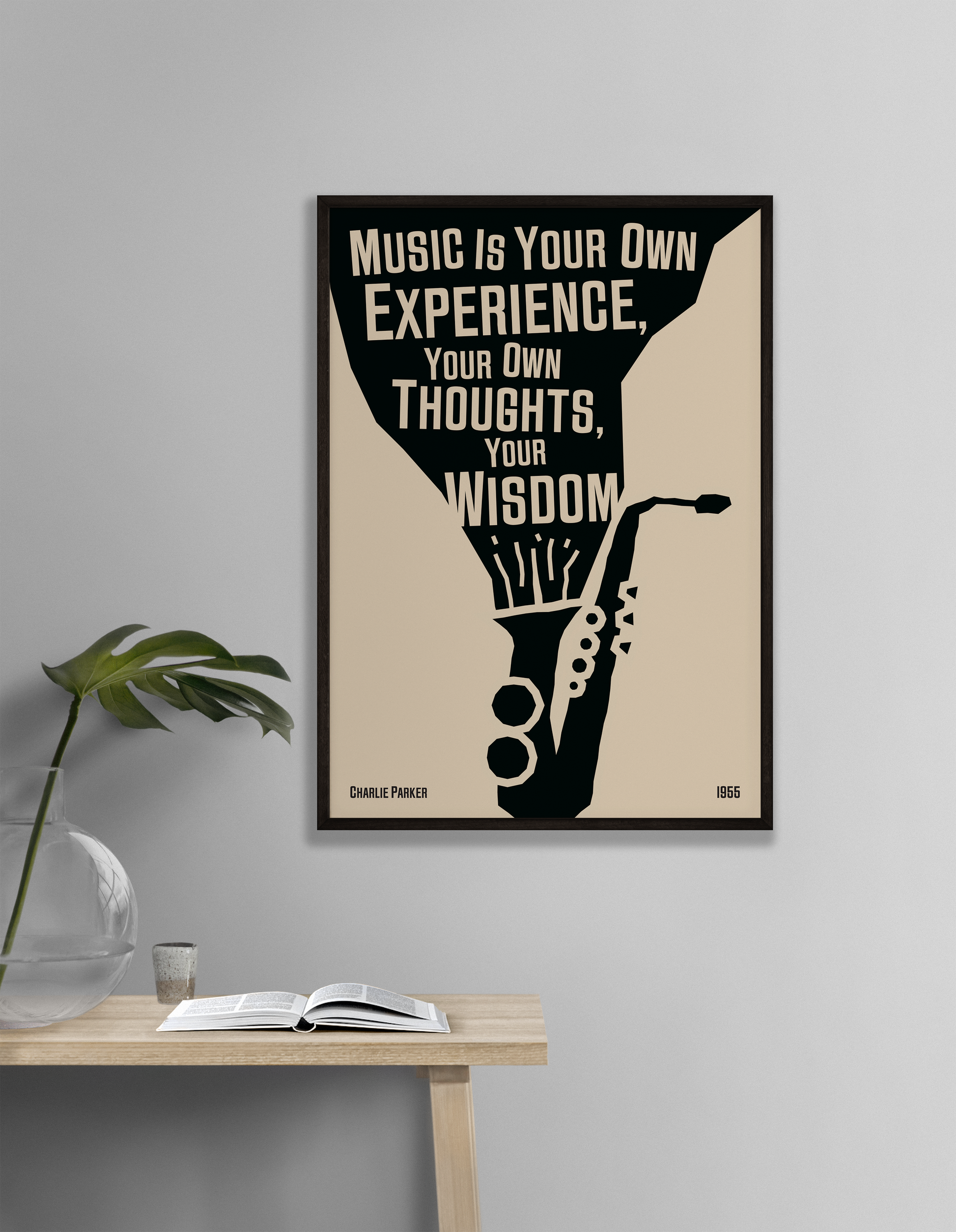 A poster featuring a black and white illustration of a saxophone with a quote by Charlie Parker, titled 'Music Is Your Own Experience, Your Own Thoughts, Your Wisdom', hanging on a white living room wall