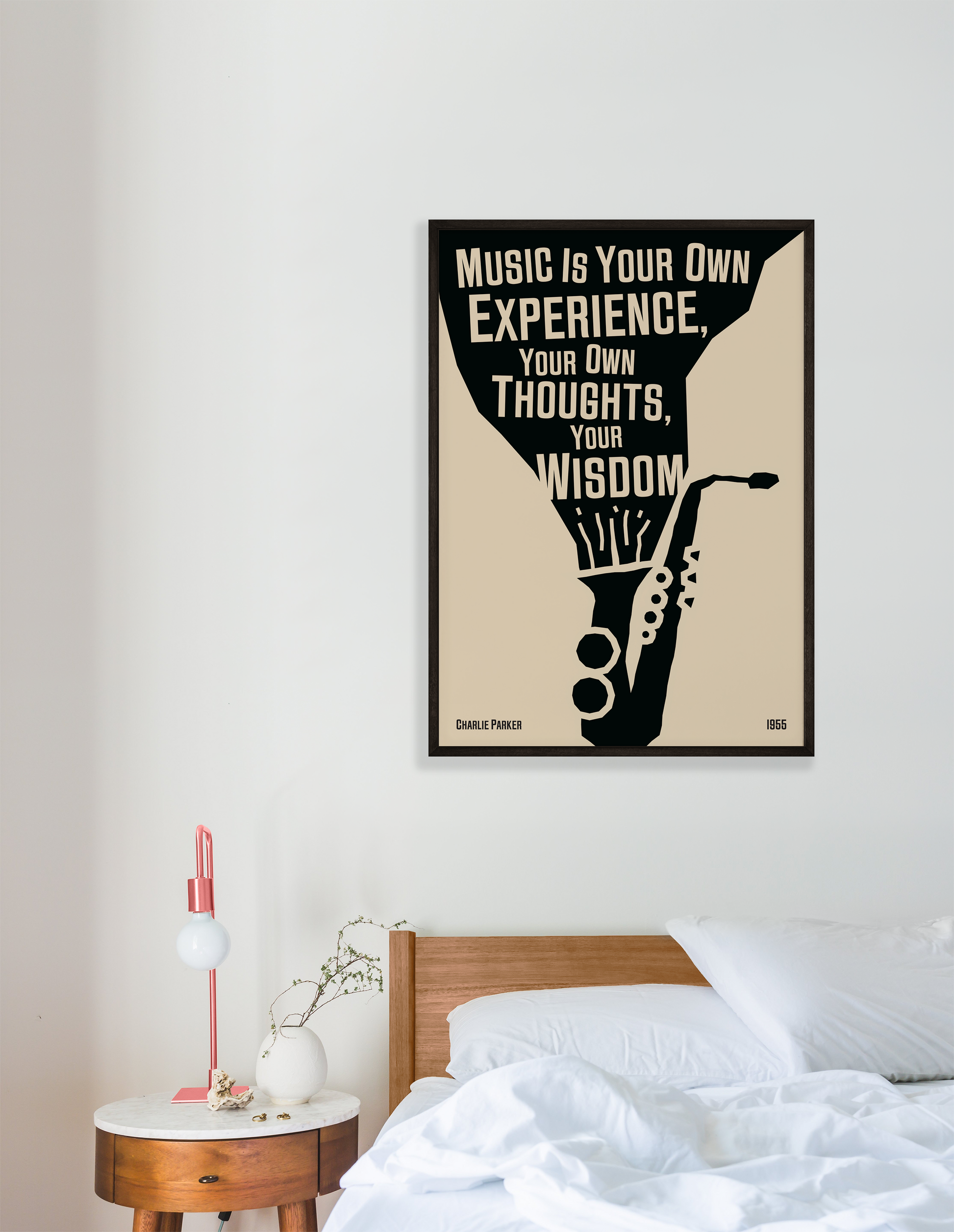 A poster featuring a black and white illustration of a saxophone with a quote by Charlie Parker, titled 'Music Is Your Own Experience, Your Own Thoughts, Your Wisdom', hanging on a white bedroom wall