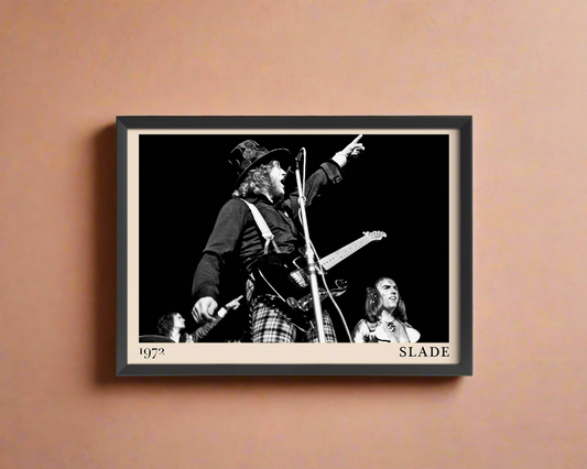 Iconic image of rock band Slade performing, captured by Heinrich Klaffs and transformed into vintage-inspired wall decor, hanging on a light peach rustic concrete wall