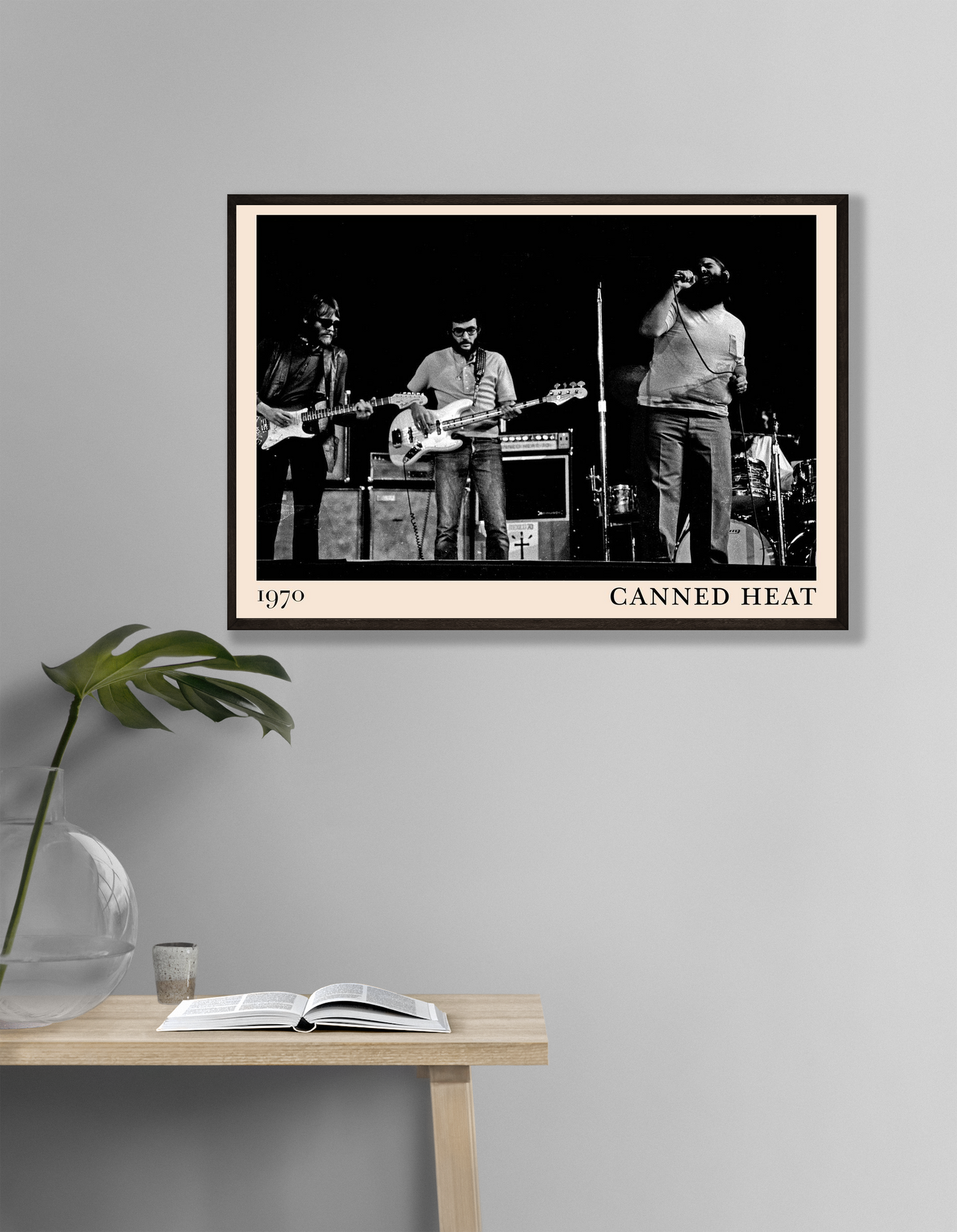 Canned Heat Poster in landscape mockup, vintage black and white band photo framed on modern gray wall above desk.