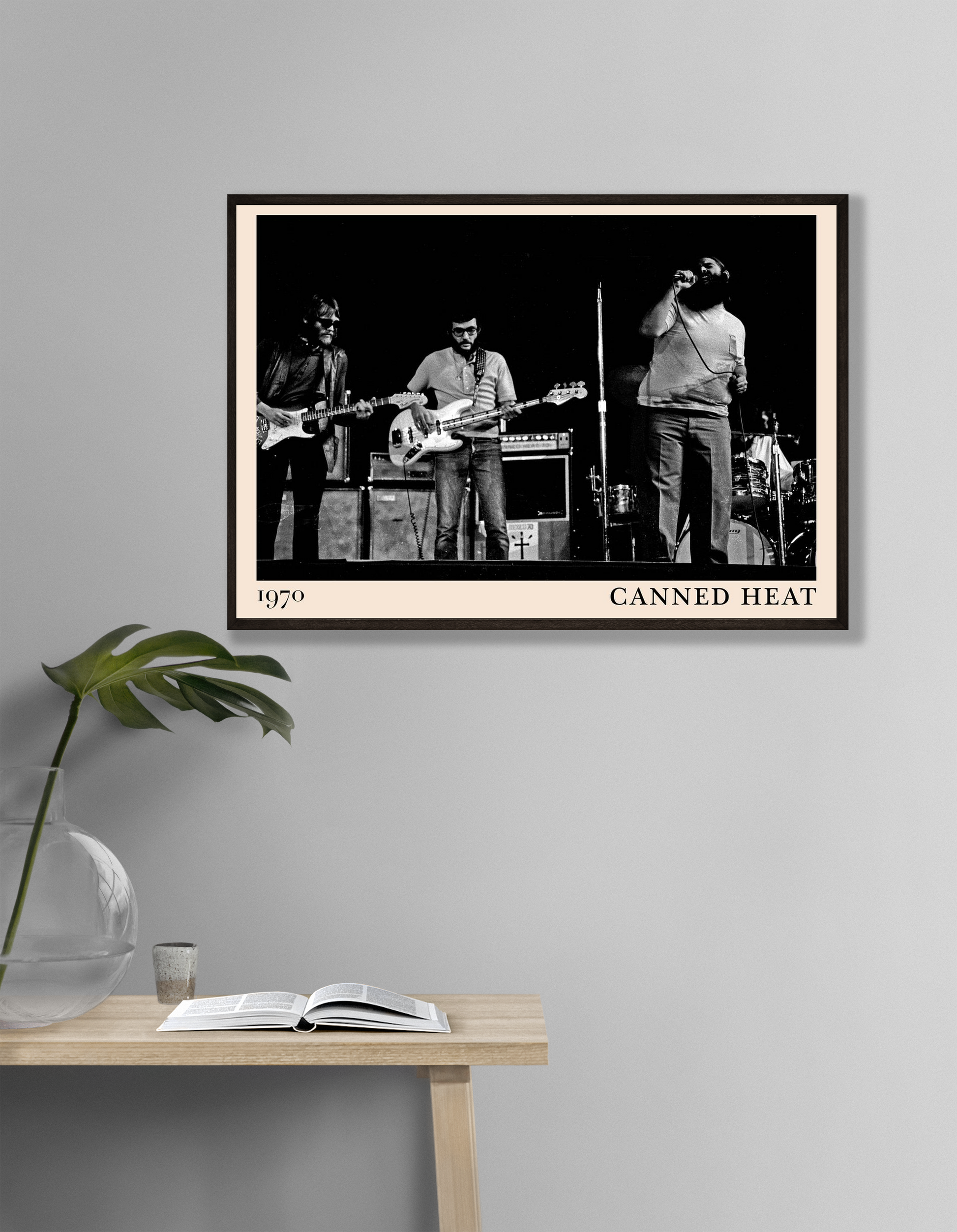 Canned Heat Poster in landscape mockup, vintage black and white band photo framed on modern gray wall above desk.