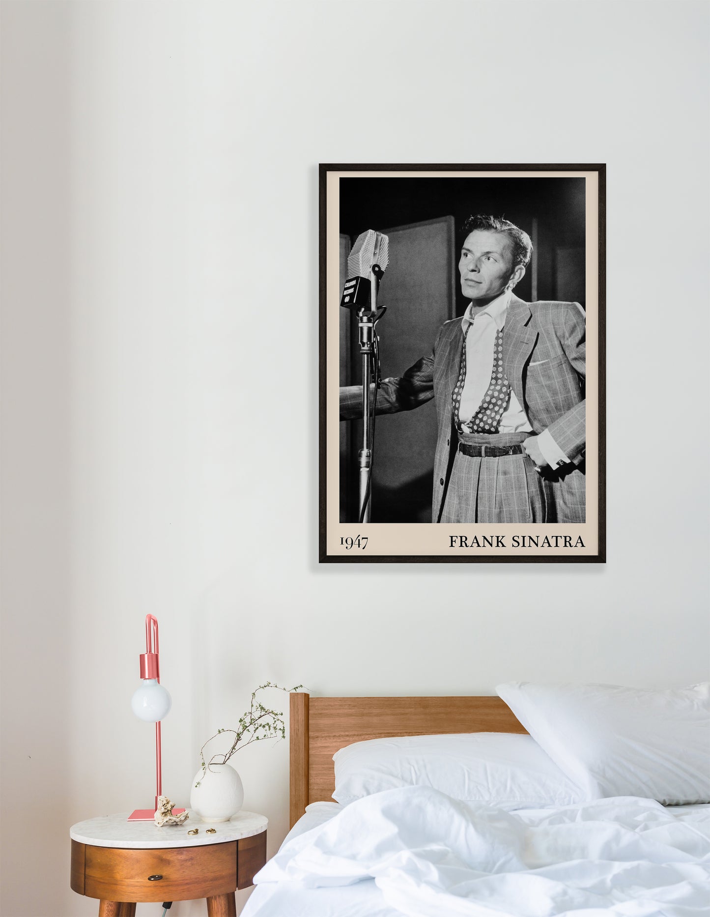 1947 photo of Frank Sinatra crafted into a black framed-poster, hanging on a white befroom wall