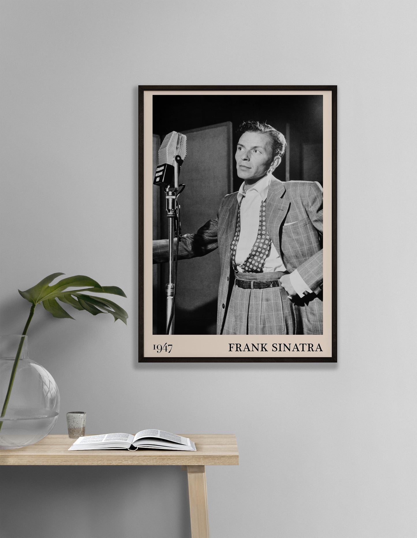 1947 photo of Frank Sinatra crafted into a black framed-poster, hanging on a white living room wall