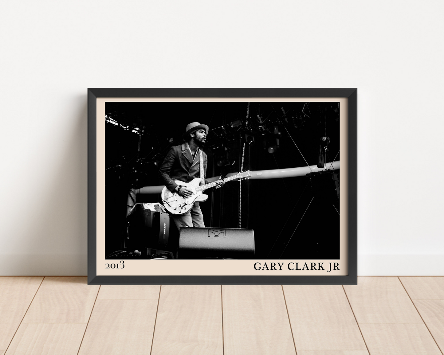 2013 photo of Gary Clark Jr crafted into an elegant black-framed print. Leaning against a white wall