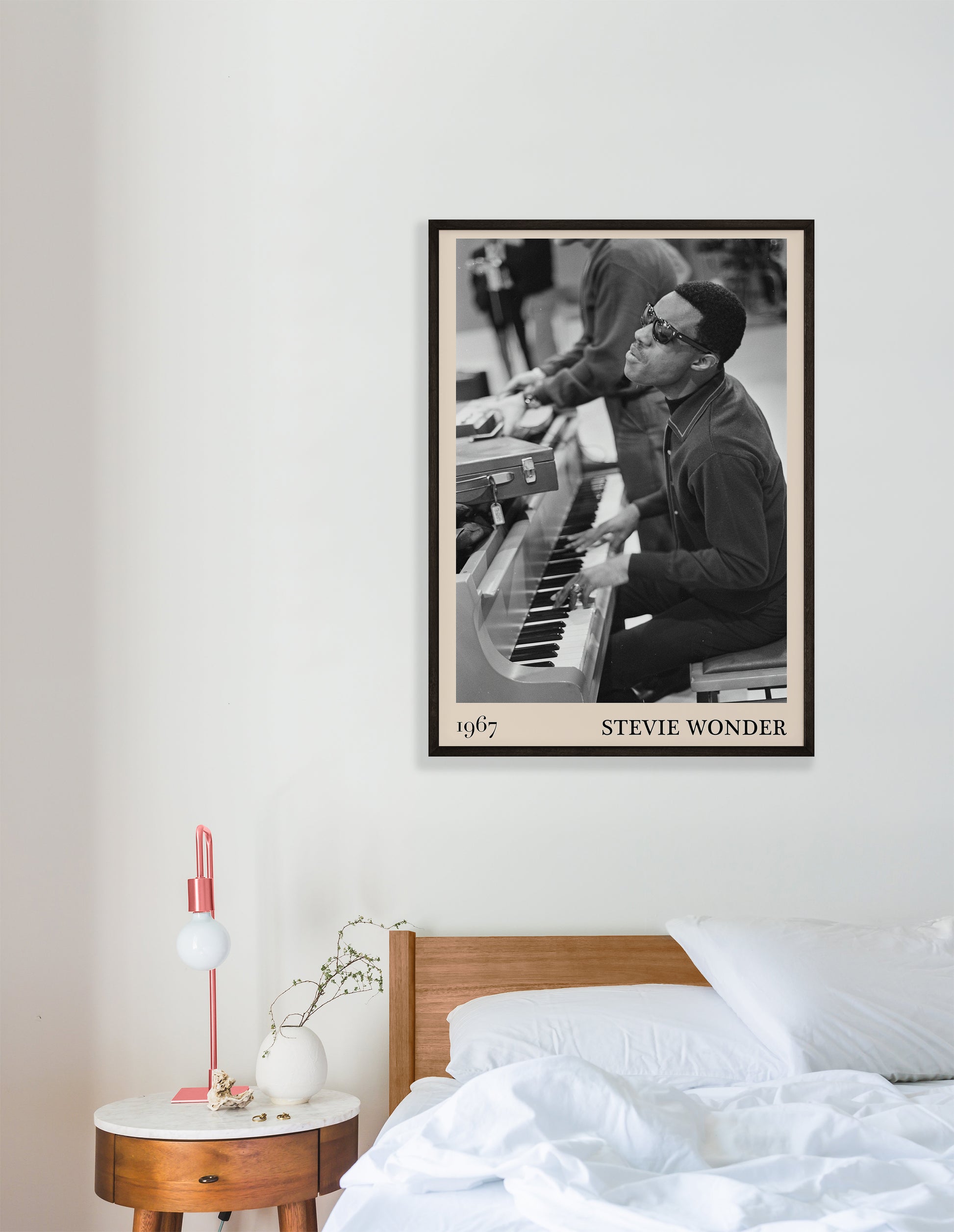 1967 photo of Stevie Wonder, crafted into an elegant black-framed print. Hanging on a white  bedroom wall
