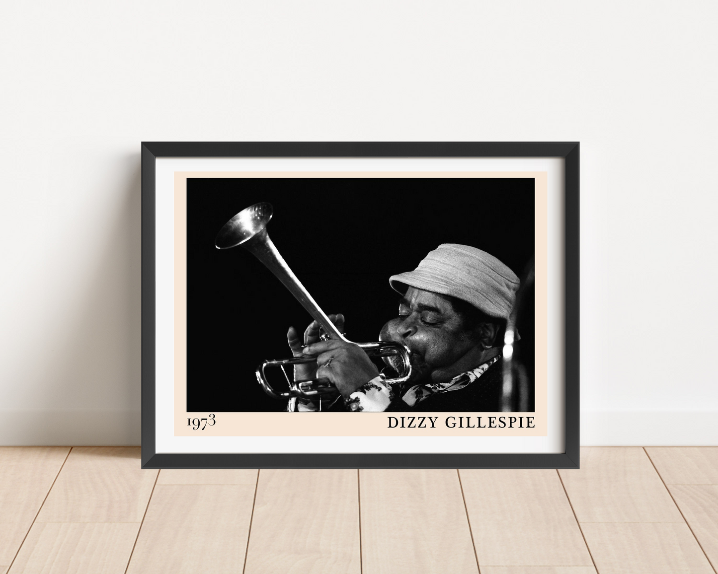 Dizzy Gillespie Jazz Concert Poster mockup in black frame on wood floor, features 1973 trumpet photo in monochrome design.
