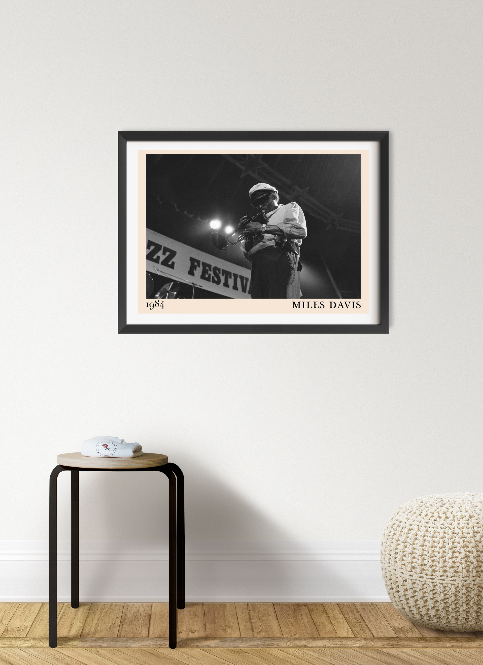 Miles Davis vintage jazz poster in a black frame, landscape 7 mount, styled on a modern living room wall above a wooden stool