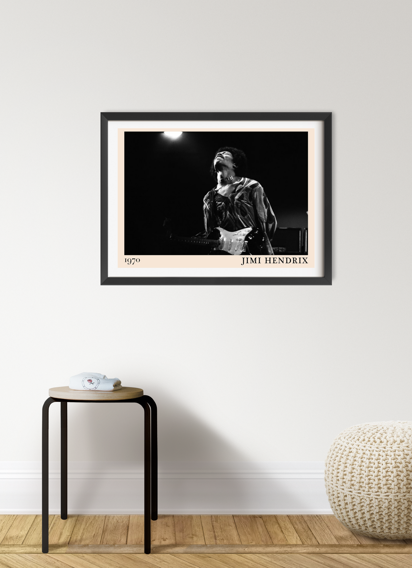 Jimi Hendrix vintage concert poster in a black frame, landscape 7 mount, displayed on a modern living room wall above a stool