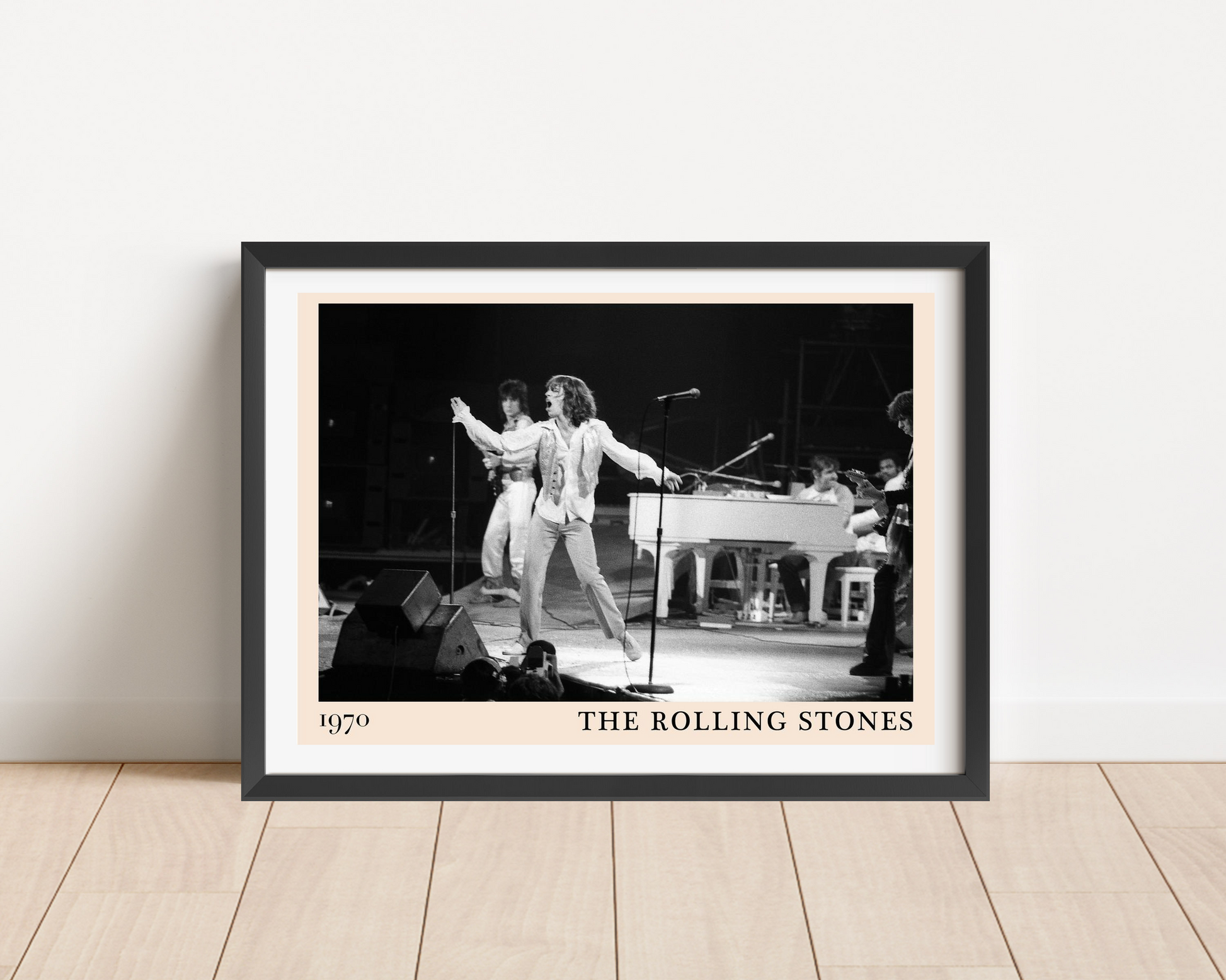The Rolling Stones Retro Concert Poster in landscape mount, black and white 1970 stage photo framed on wood floor.