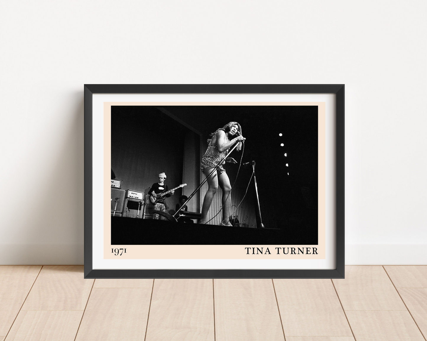 Tina Turner retro concert poster in landscape mount mockup, framed on wood floor, features bold black and white stage photo.