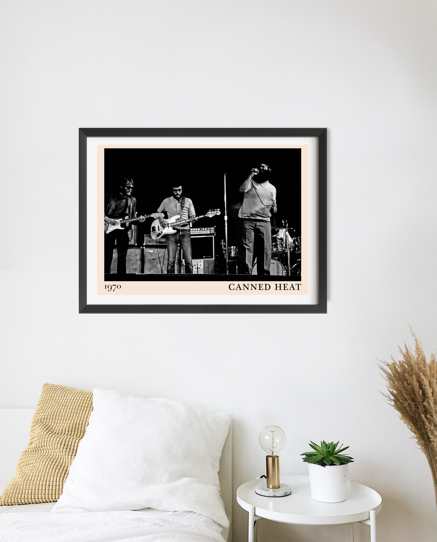 Canned Heat poster in landscape 20 mount mockup above a bed, featuring black and white band photo with modern frame.