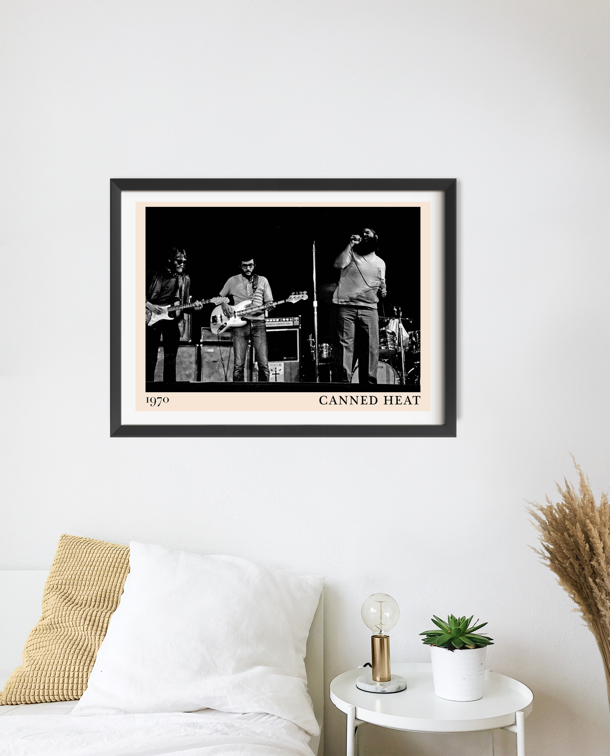 Canned Heat poster in landscape 20 mount mockup above a bed, featuring black and white band photo with modern frame.