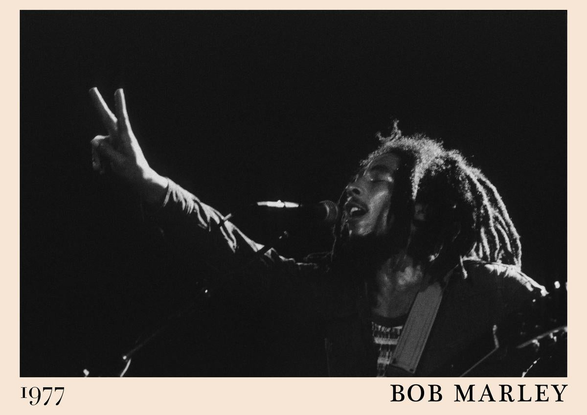 Poster featuring Bob Marley singing and flashing a peace sign on stage, black and white 1977 retro design, framed wall art