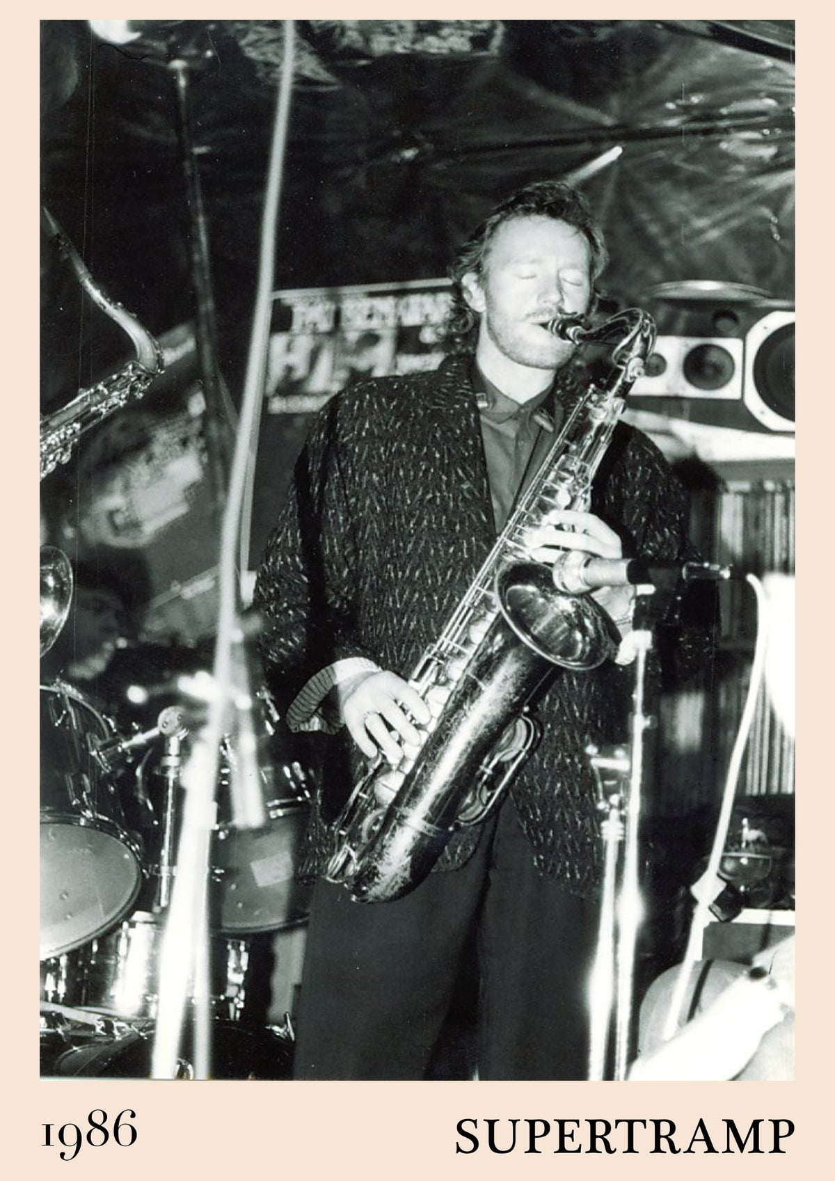 Black and white photo of Supertramp's John Helliwell playing saxophone on stage, captioned 1986 and SUPERTRAMP