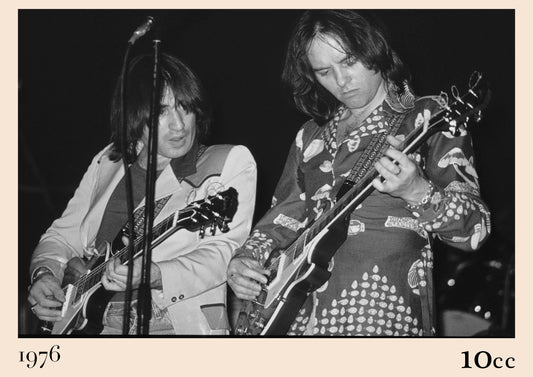 Black and white photo of 10cc's Eric Stewart and Lol Creme playing electric guitars on stage, captioned 1976 and 10cc