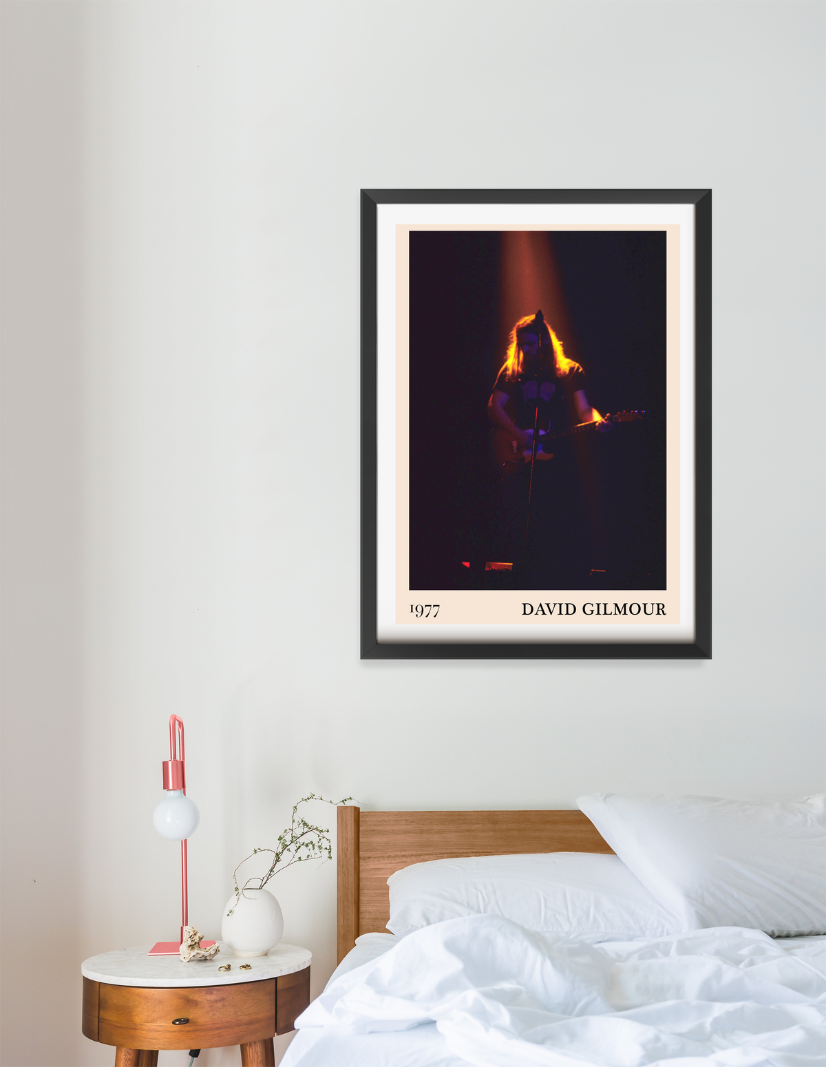 David Gilmour 1977 framed print in black frame, concert stage photo with dramatic lighting, hung above a wooden bedside