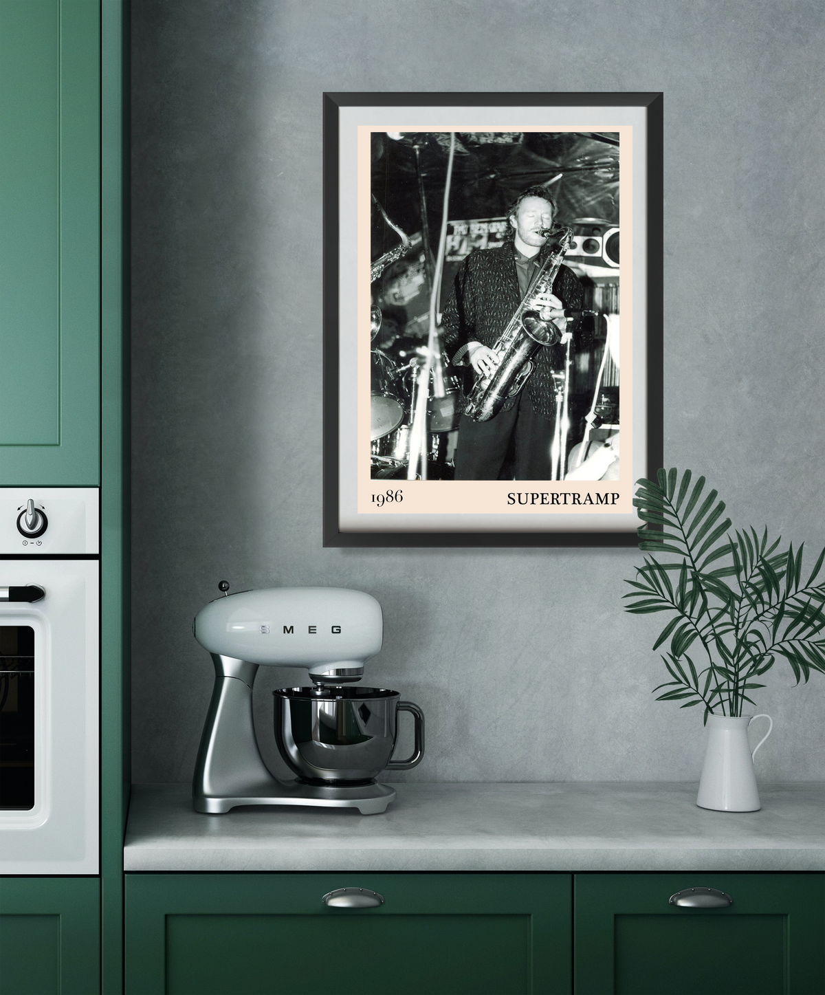 Framed Supertramp 1986 concert print hung in a green kitchen, showing a black and white photo of a saxophonist on stage.