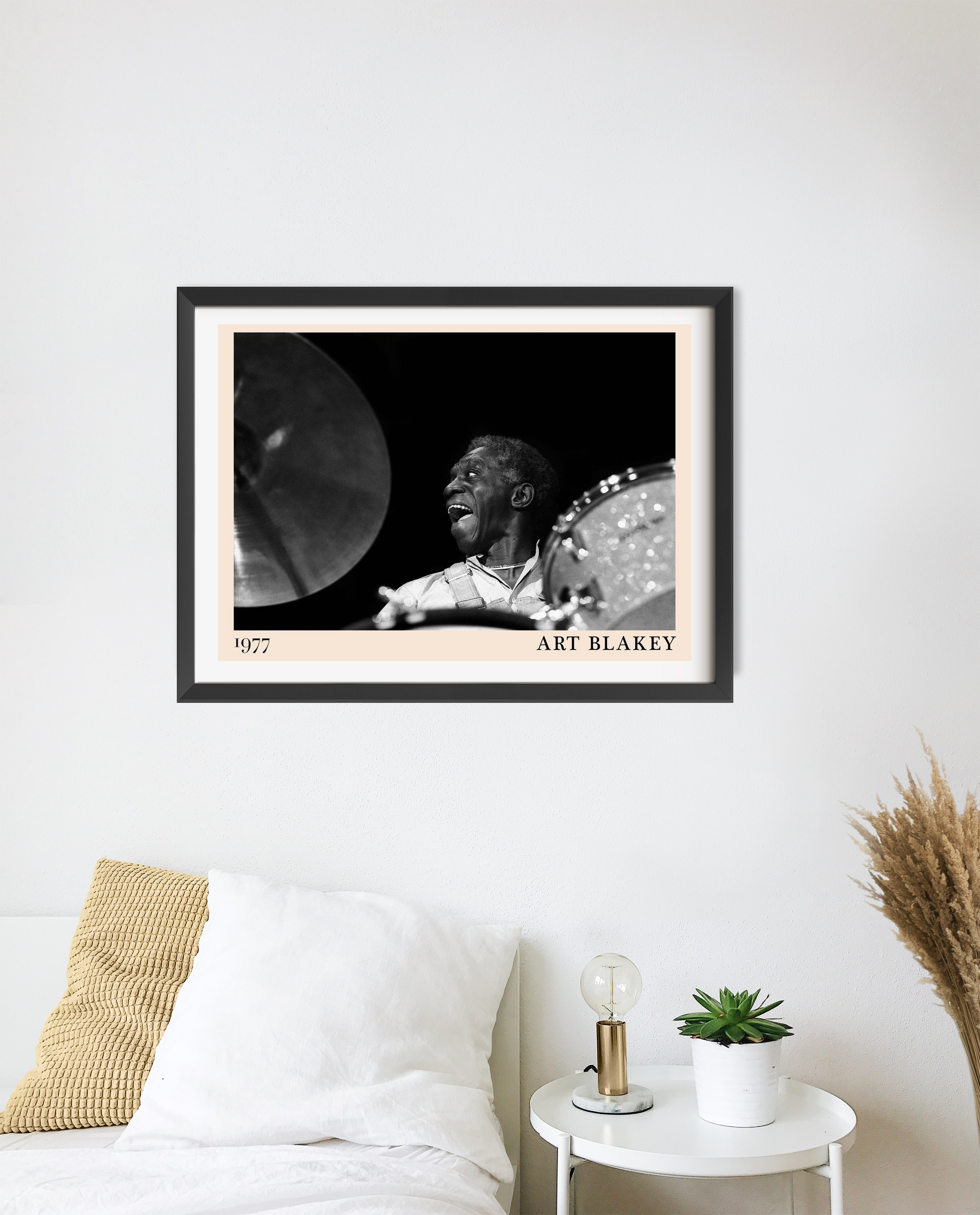 Art Blakey vintage jazz poster in landscape 20 mount mockup above a cozy bed, monochrome drummer design, modern decor style