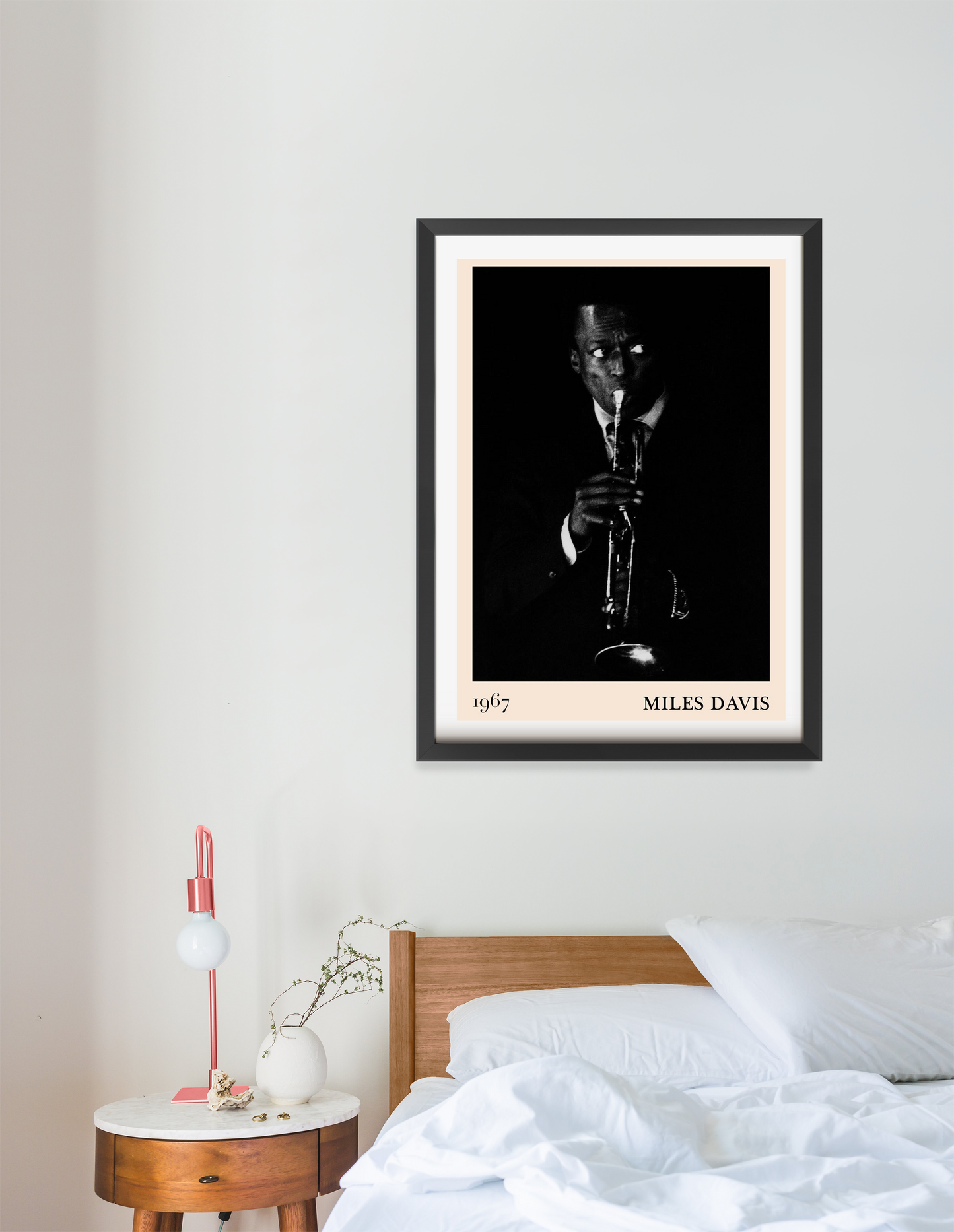 Miles Davis vintage jazz poster in a black frame, portrait 16 mount, displayed above a modern wooden bed in a minimalist bedr