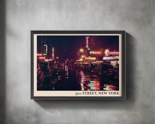 Iconic 52nd Street in New York captured in a retro black framed jazz poster, hanging on a grey wall in dappled sunlight