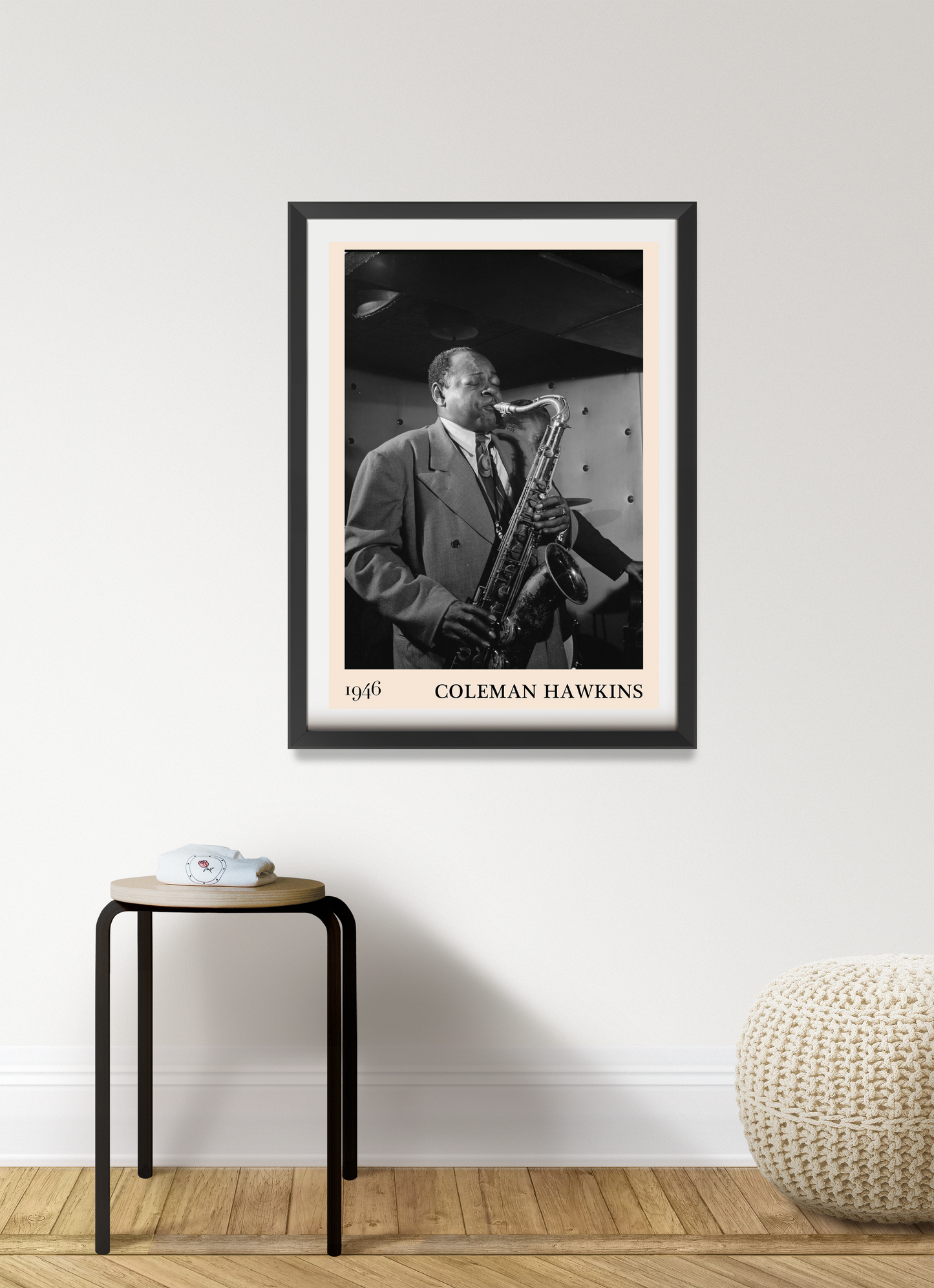 Coleman Hawkins Jazz Concert Poster in black frame, portrait 7 mount, displayed on modern wall above wooden stool and pouf.