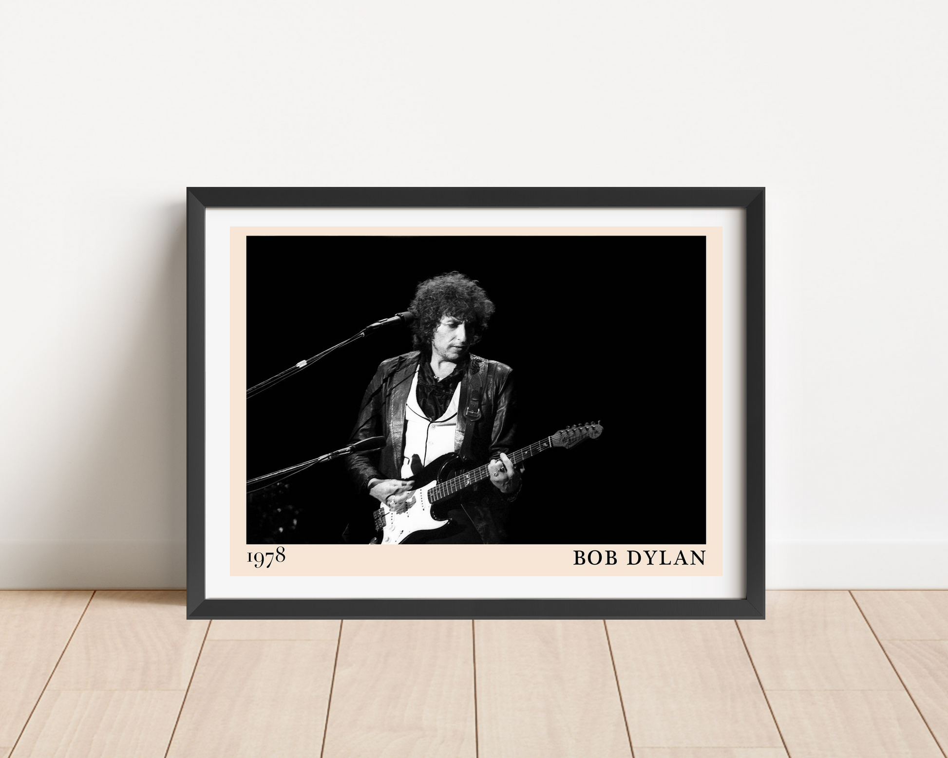 Bob Dylan Folk Concert Poster in landscape mount mockup, black frame on wood floor, features 1978 guitar performance design
