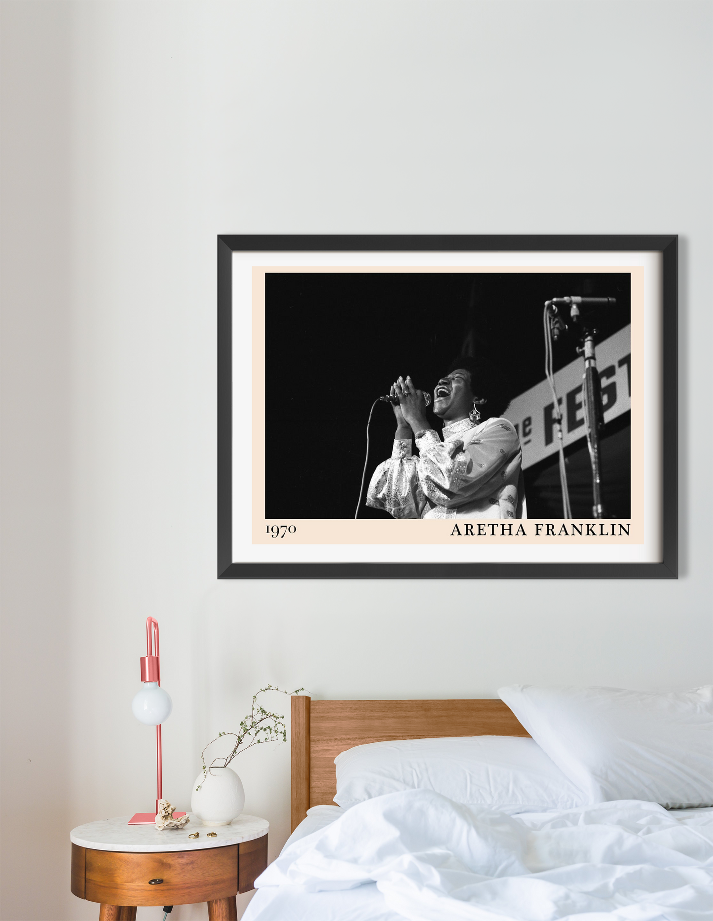 Aretha Franklin vintage jazz poster in a black frame, landscape 16 mount, styled above a modern bed and nightstand in a cozy