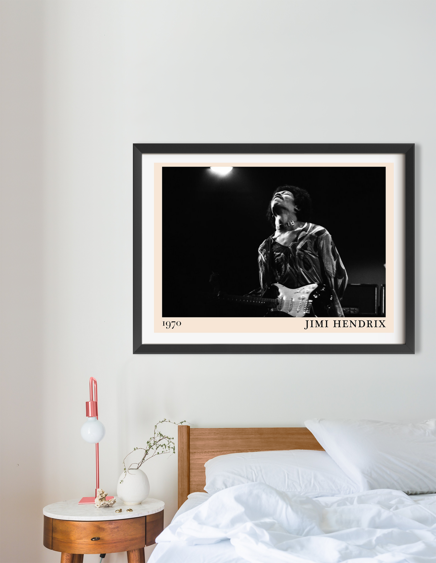 Jimi Hendrix vintage concert poster in landscape 16 mount mockup, black frame above modern wooden bed in minimal bedroom deco