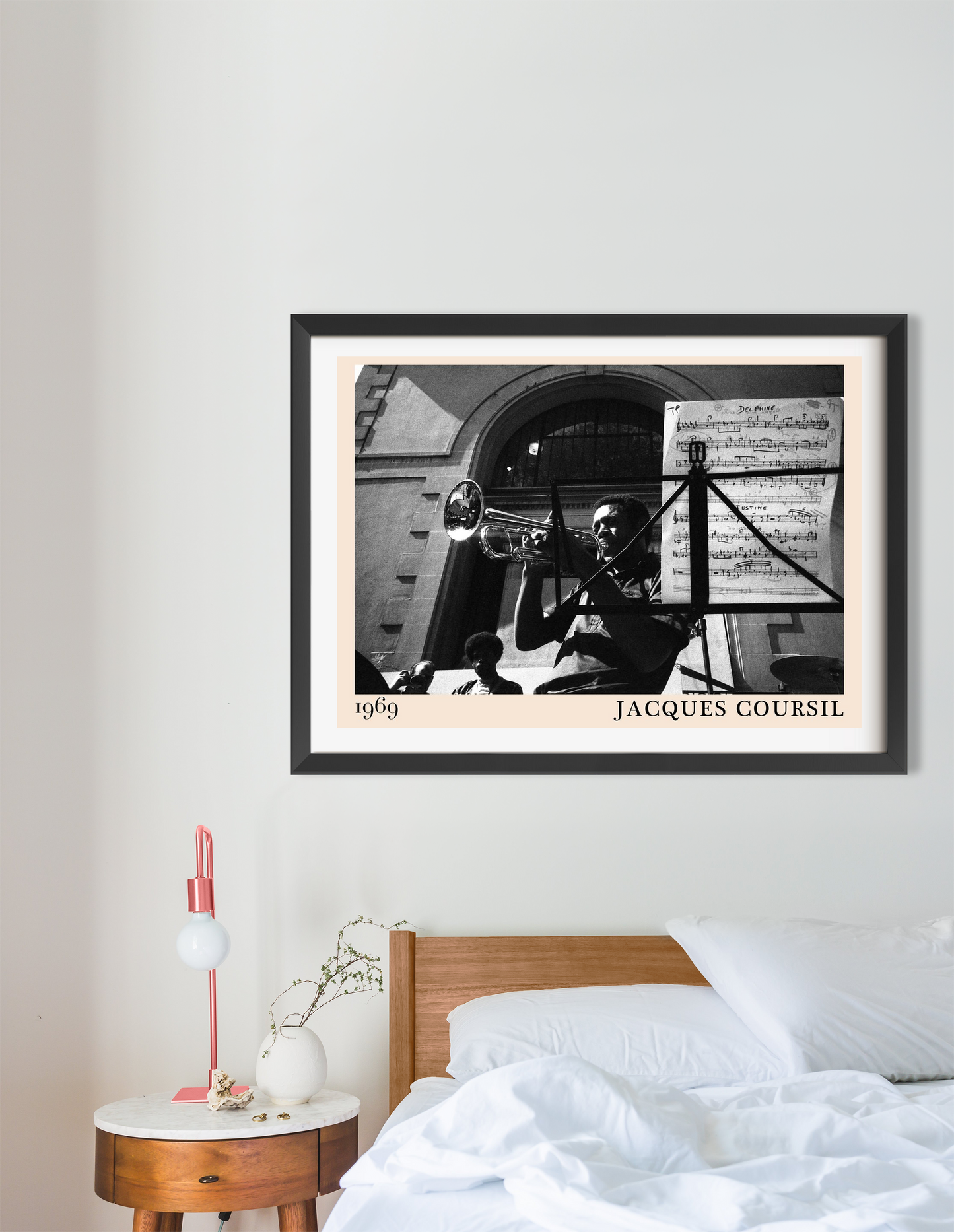 Jacques Coursil vintage jazz poster in a black frame, landscape 16 mount, styled above a modern wooden bed in a minimalist be
