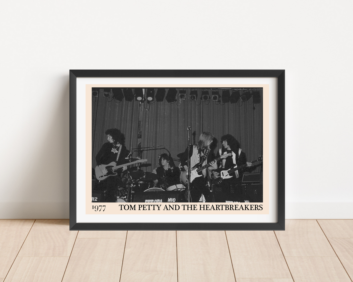 Framed print of Tom Petty and the Heartbreakers performing live in 1977, black and white concert photo, leaning against a