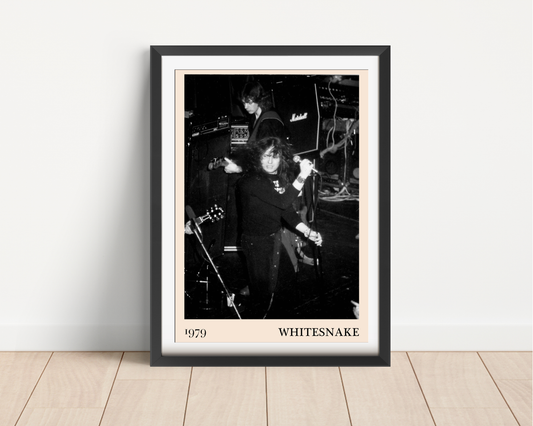 Whitesnake 1979 framed print leaning against a white wall on light wood flooring, featuring a black and white concert photo