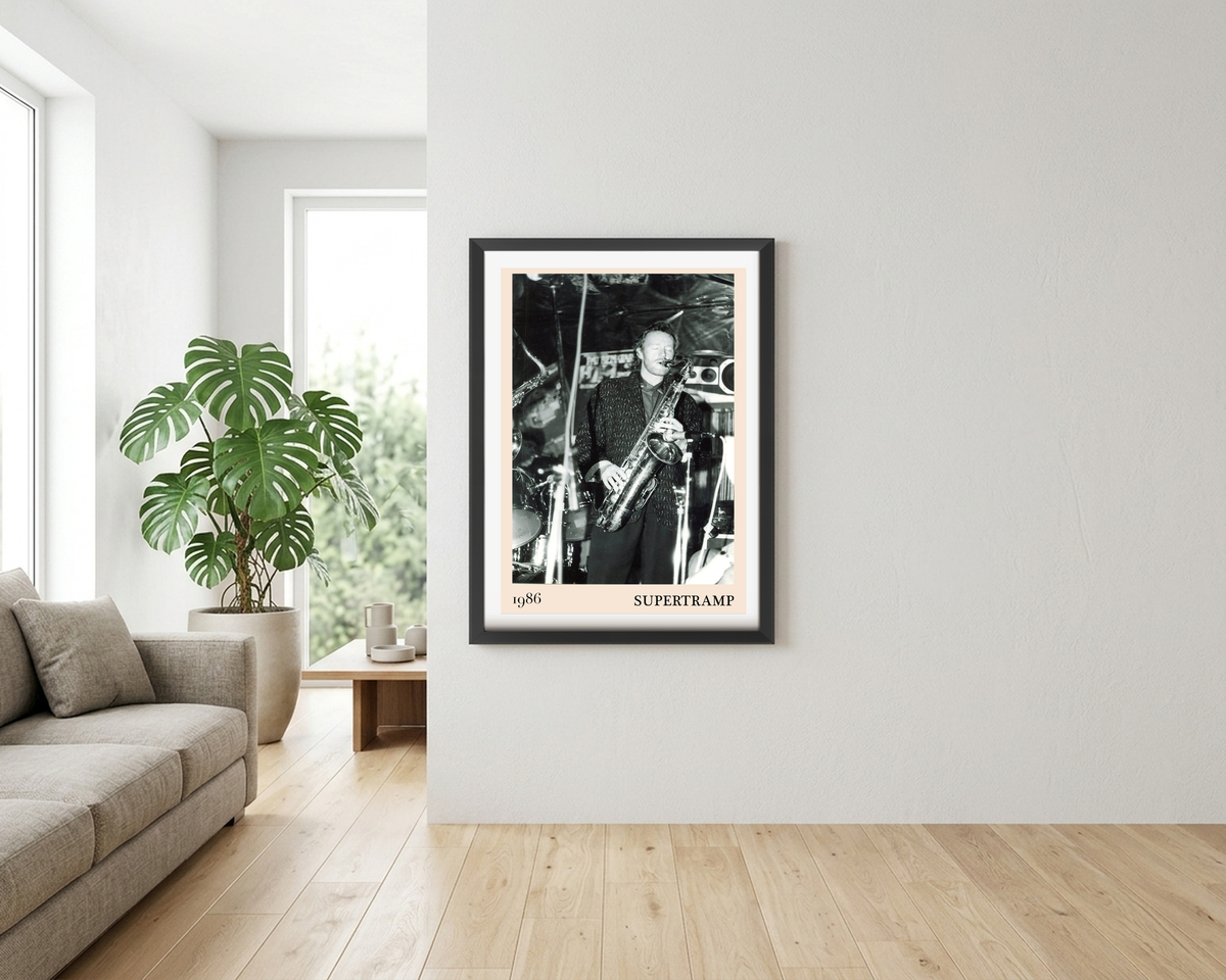 Framed Supertramp 1986 concert print hanging in a bright living room, featuring a black and white photo of a saxophonist on