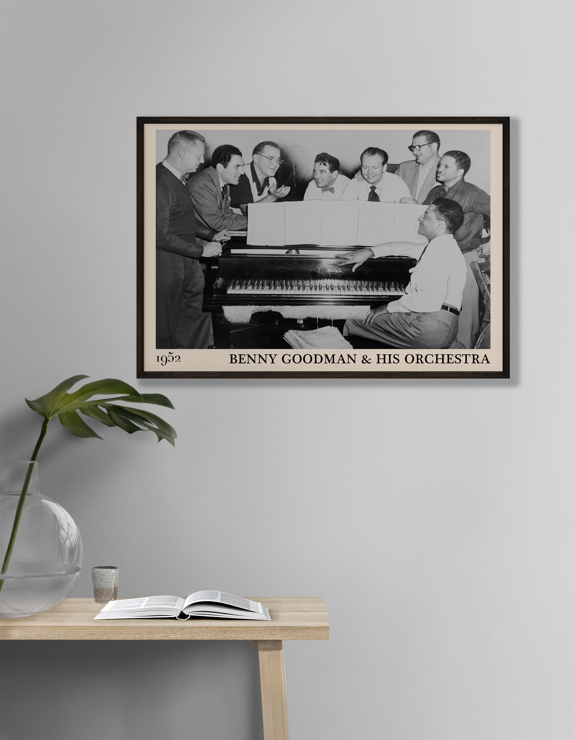 1952 photograph of Benny Goodman & his orchestra crafted into a black framed jazz poster. The poster is hanging on a grey living room wall.