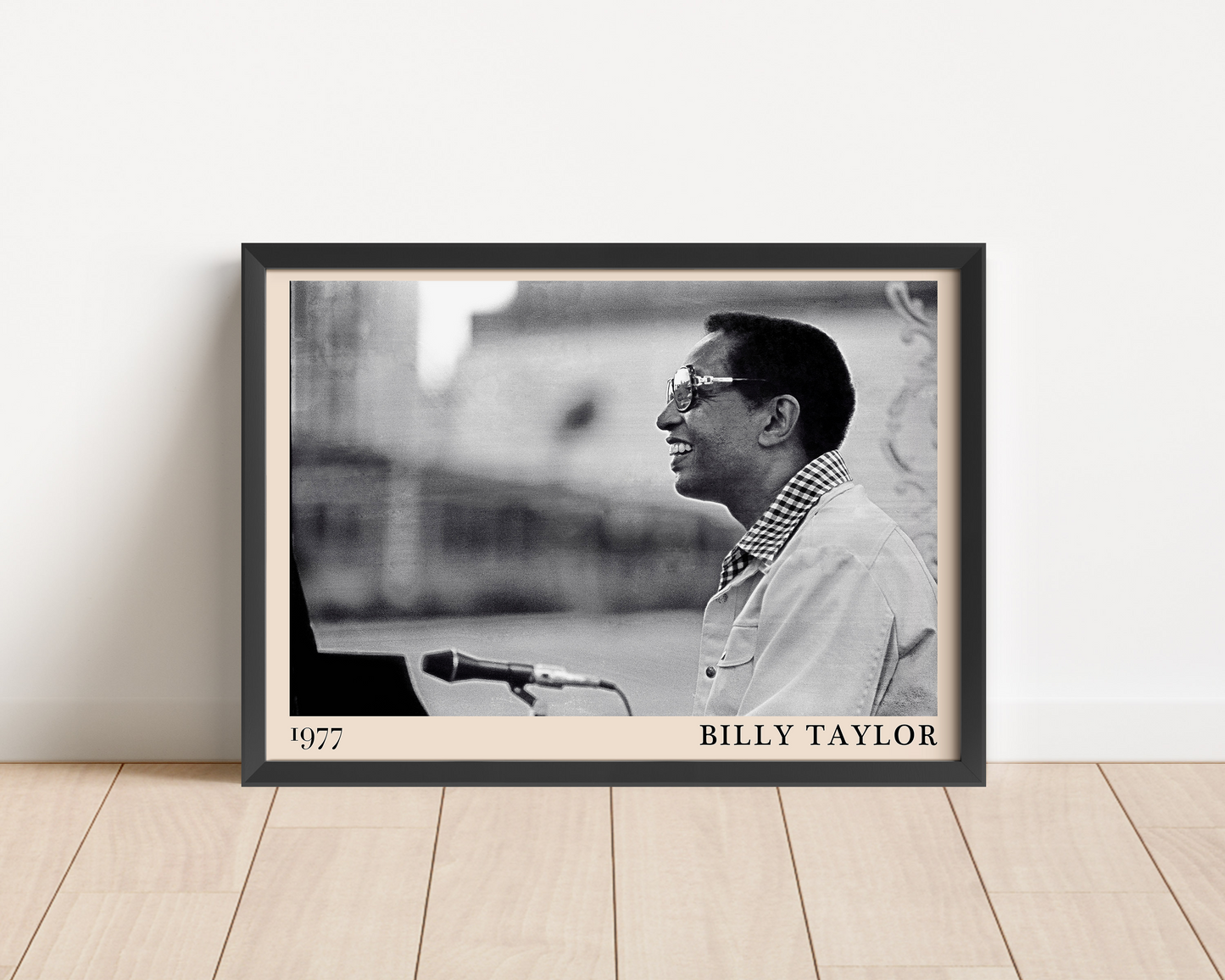 1977 photograph of Billy Taylor taken by Thomas Marcello. Picture crafted into a black framed poster, with an off-white border. Poster is propped against a white wall