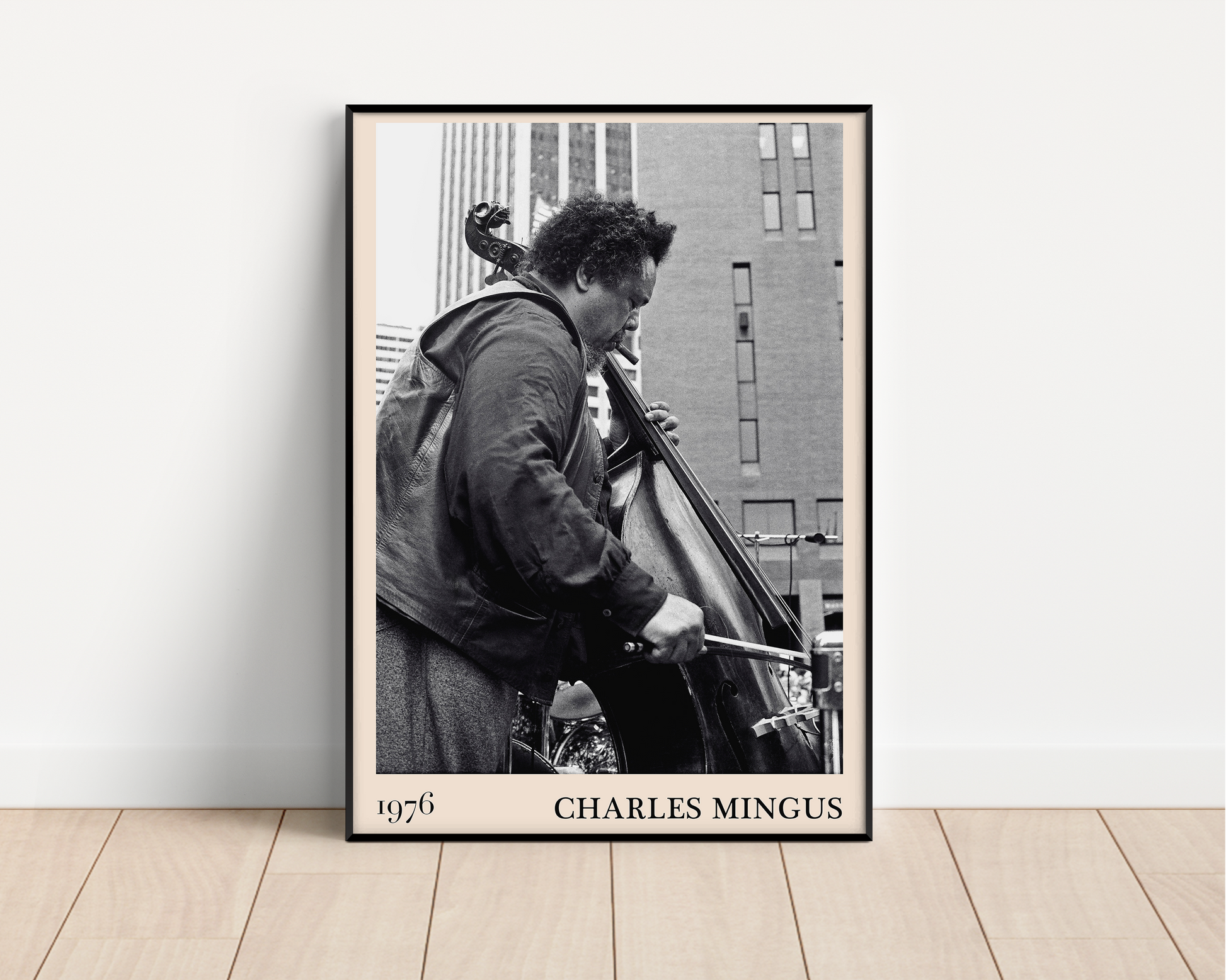 1976 photograph of Charles Mingus taken by Thomas Marcello. Picture crafted into a black framed poster, with an off-white border. Poster is propped against a white wall.