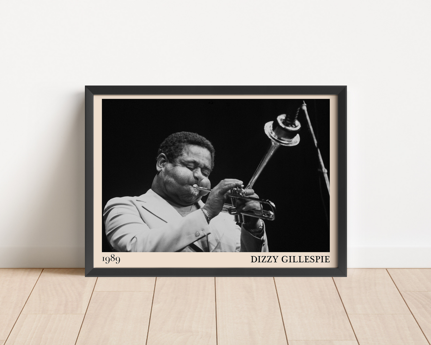 1989 photograph of Dizzy Gillespie playing the trumpet, transformed into a stylish black-framed jazz poster leaning against a white wall