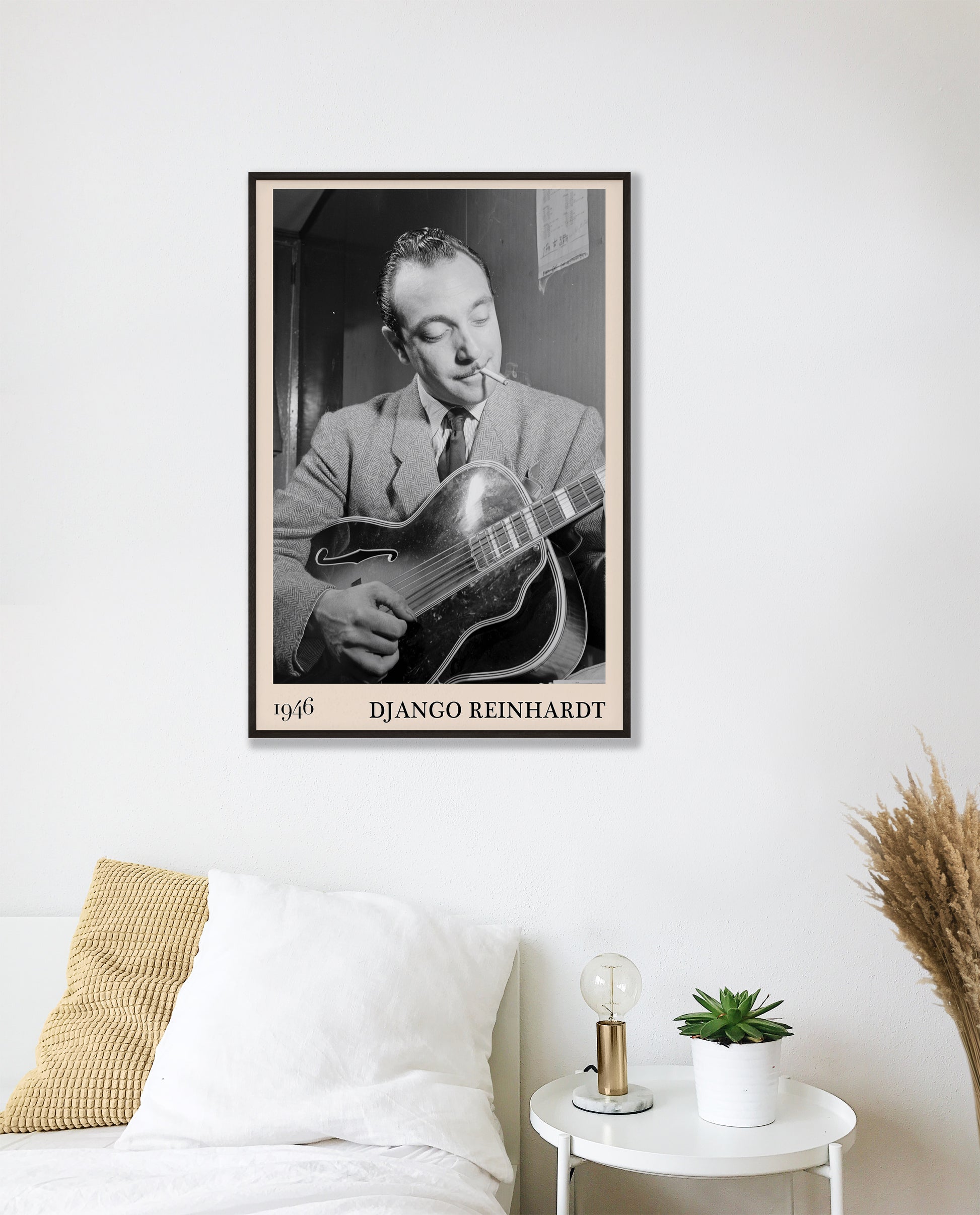 1946 photograph of Django Reinhardt playing the guitar. Transformed into a retro black-framed jazz poster hanging on a white bedroom wall